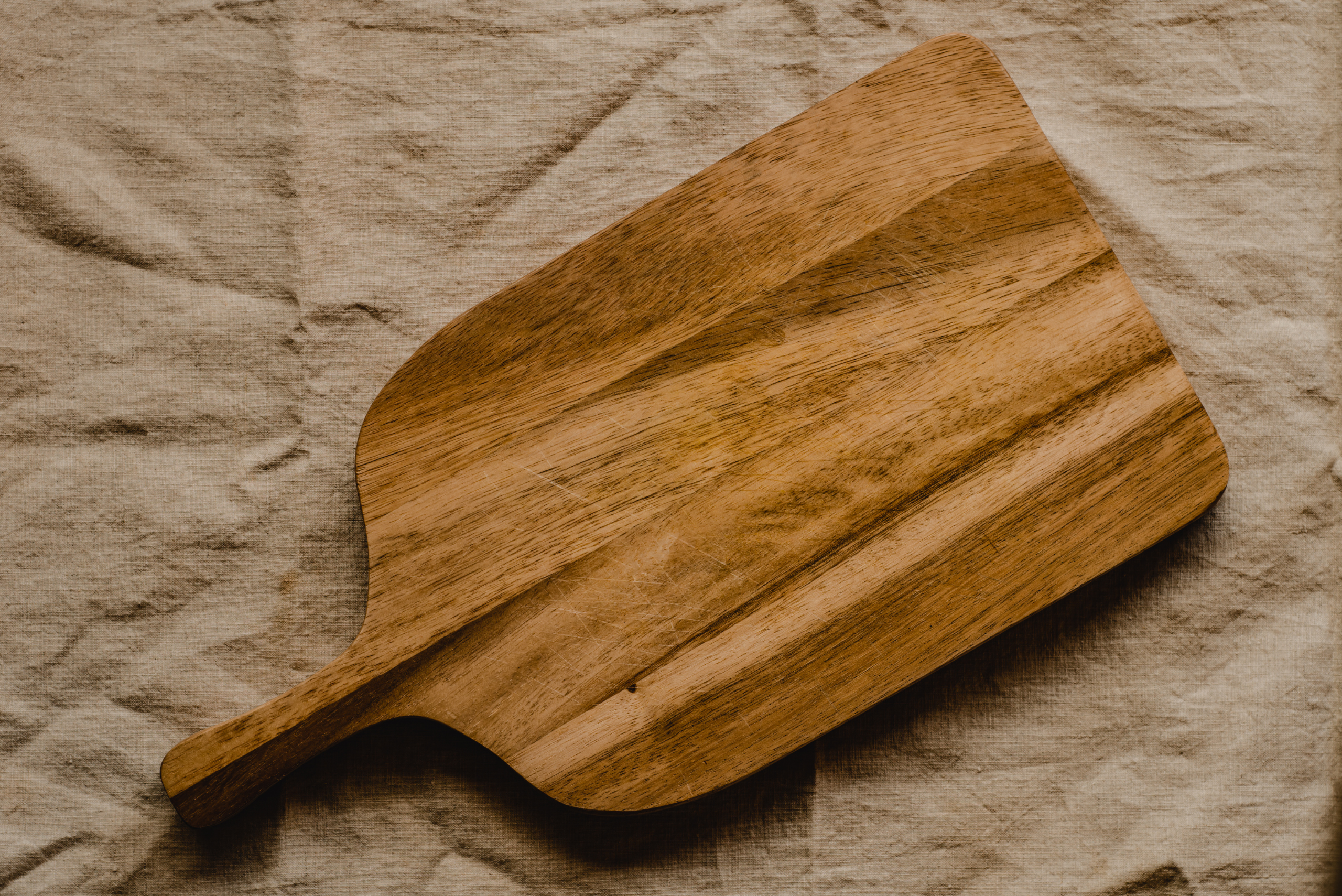 A wooden cutting board on a fabric sheet.