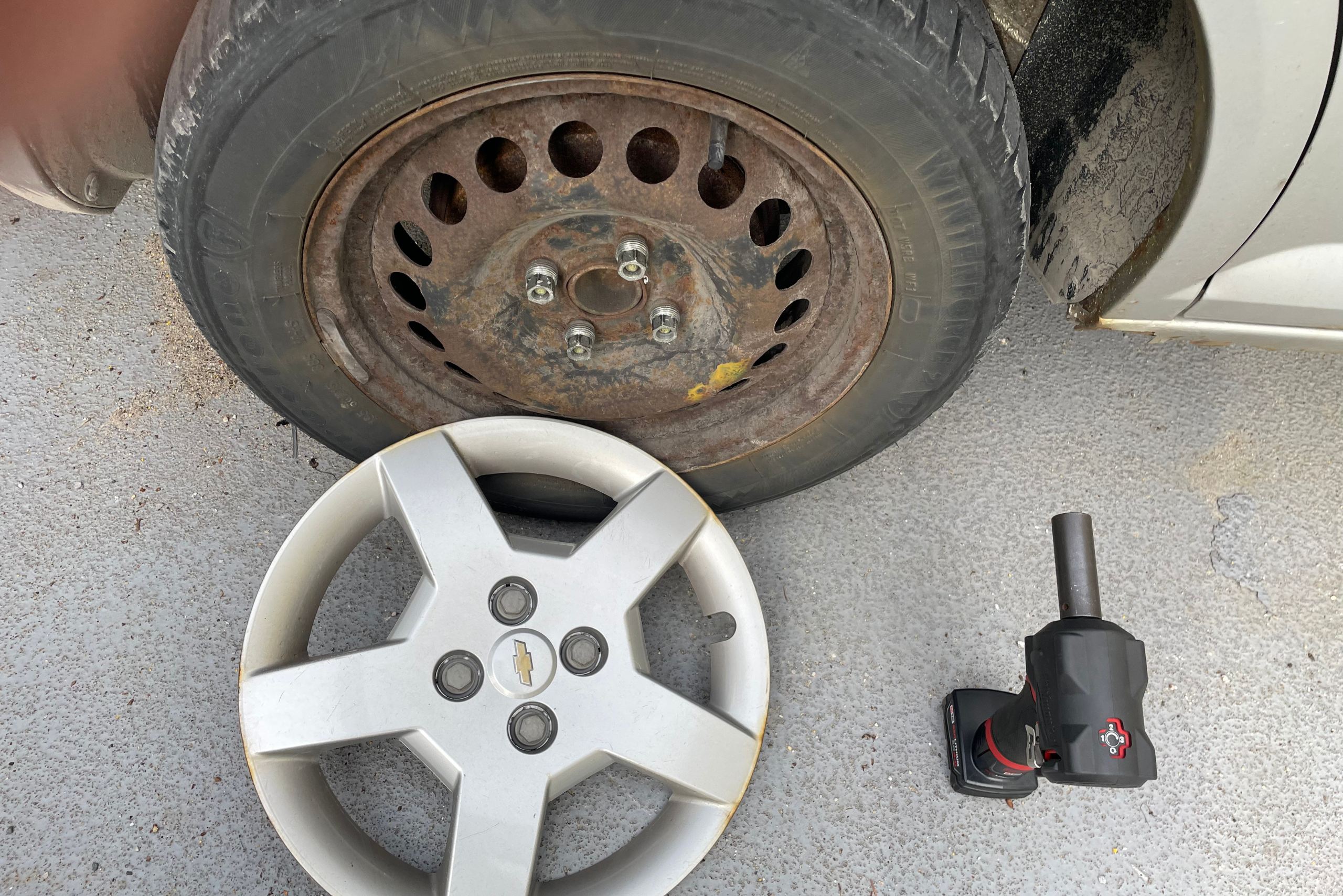 A wheel hub cap removed flanked by wheel.
