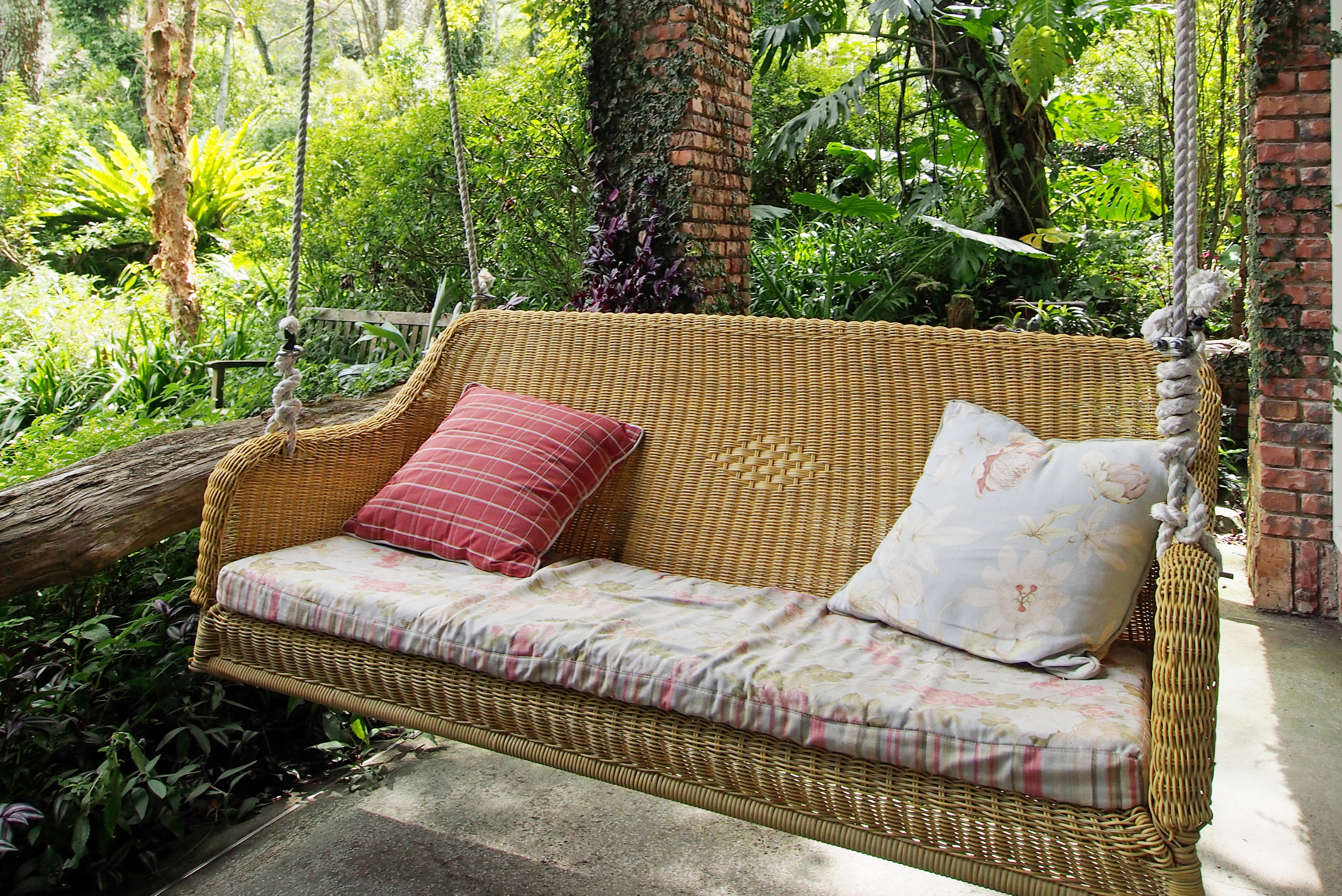 A patio swing made of whicker material.