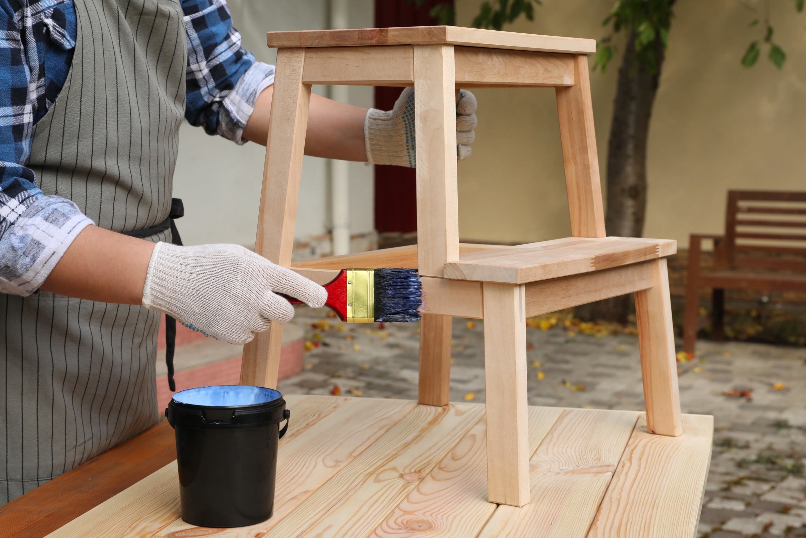 A person finishing wood stepping stool.