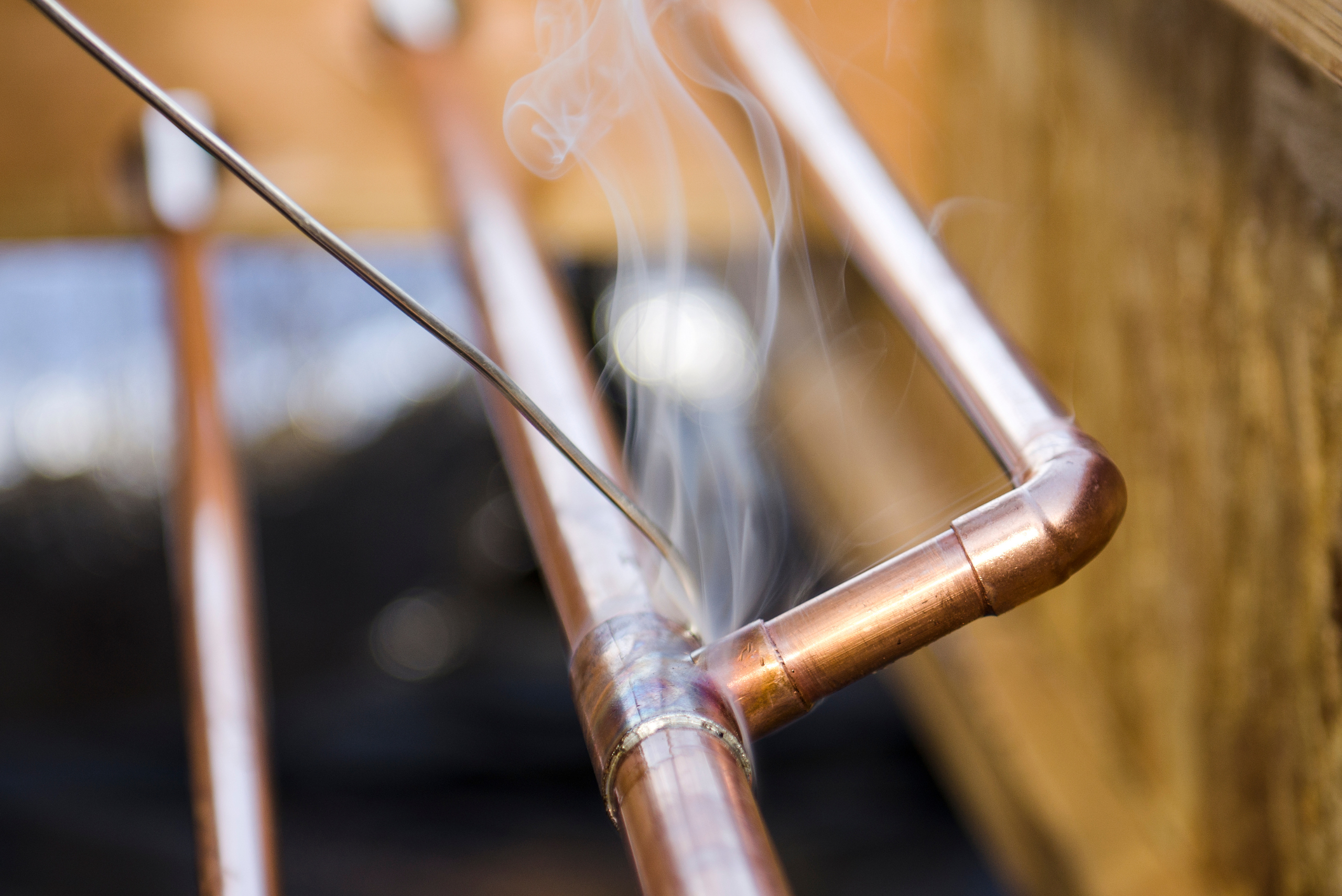 A copper pipe steaming while being soldiered.
