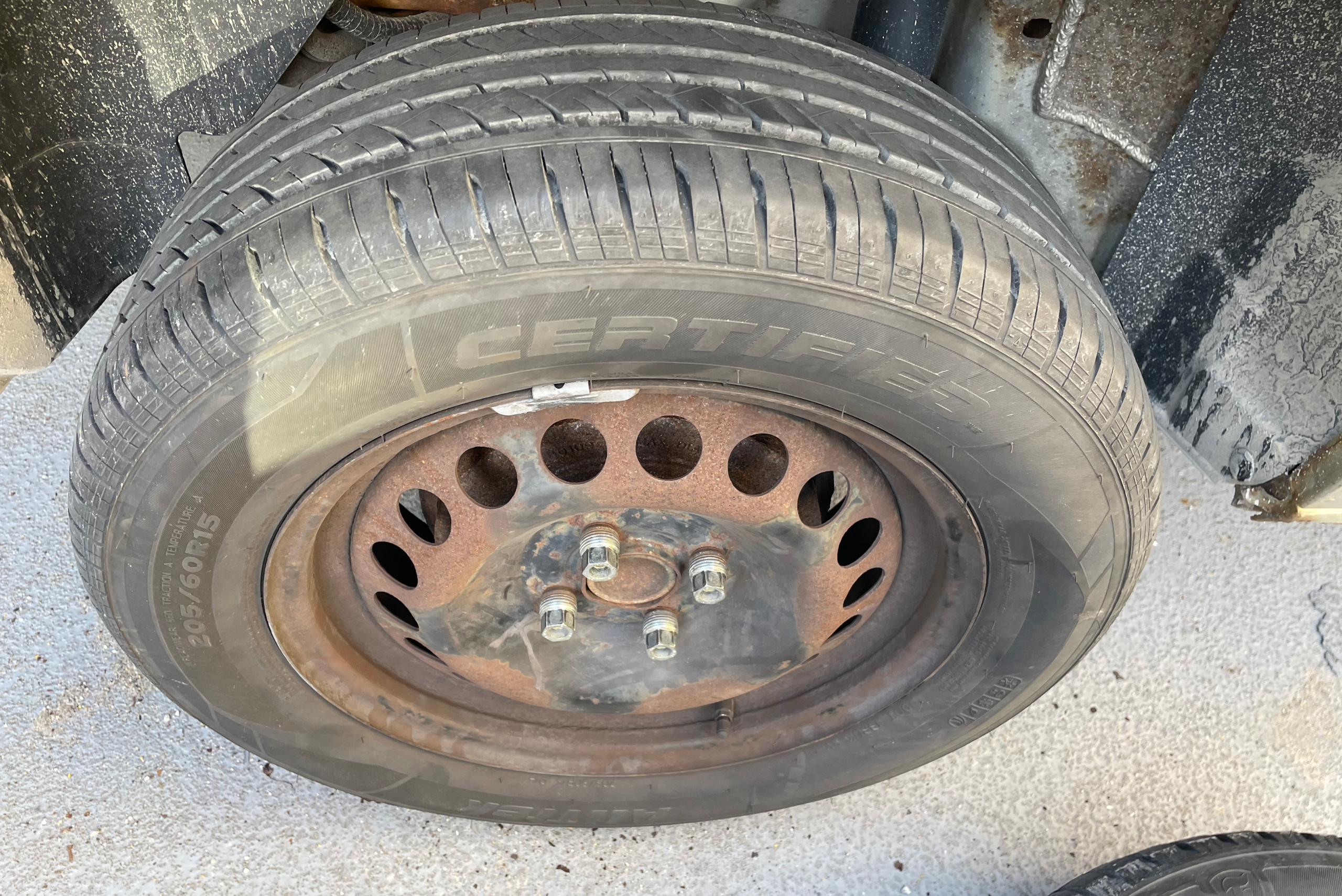 A summer tire installed onto a vehicle.