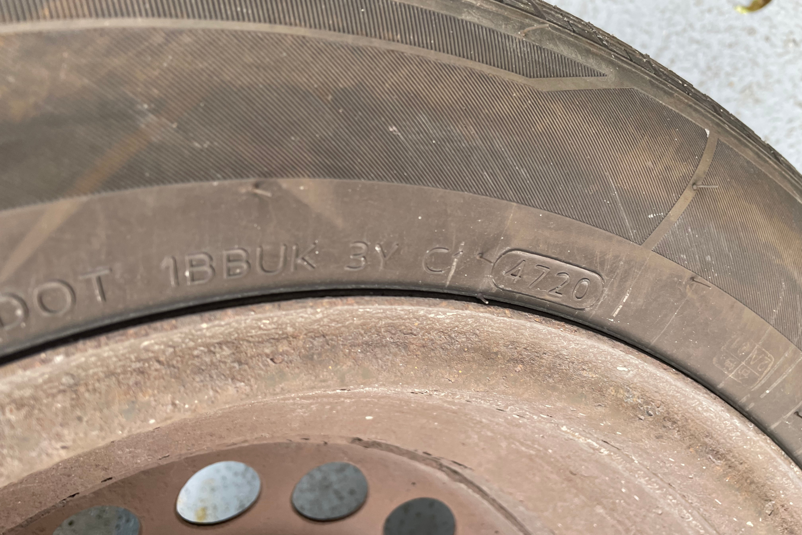 A closeup of a tire, showing manufacturing date stamp.