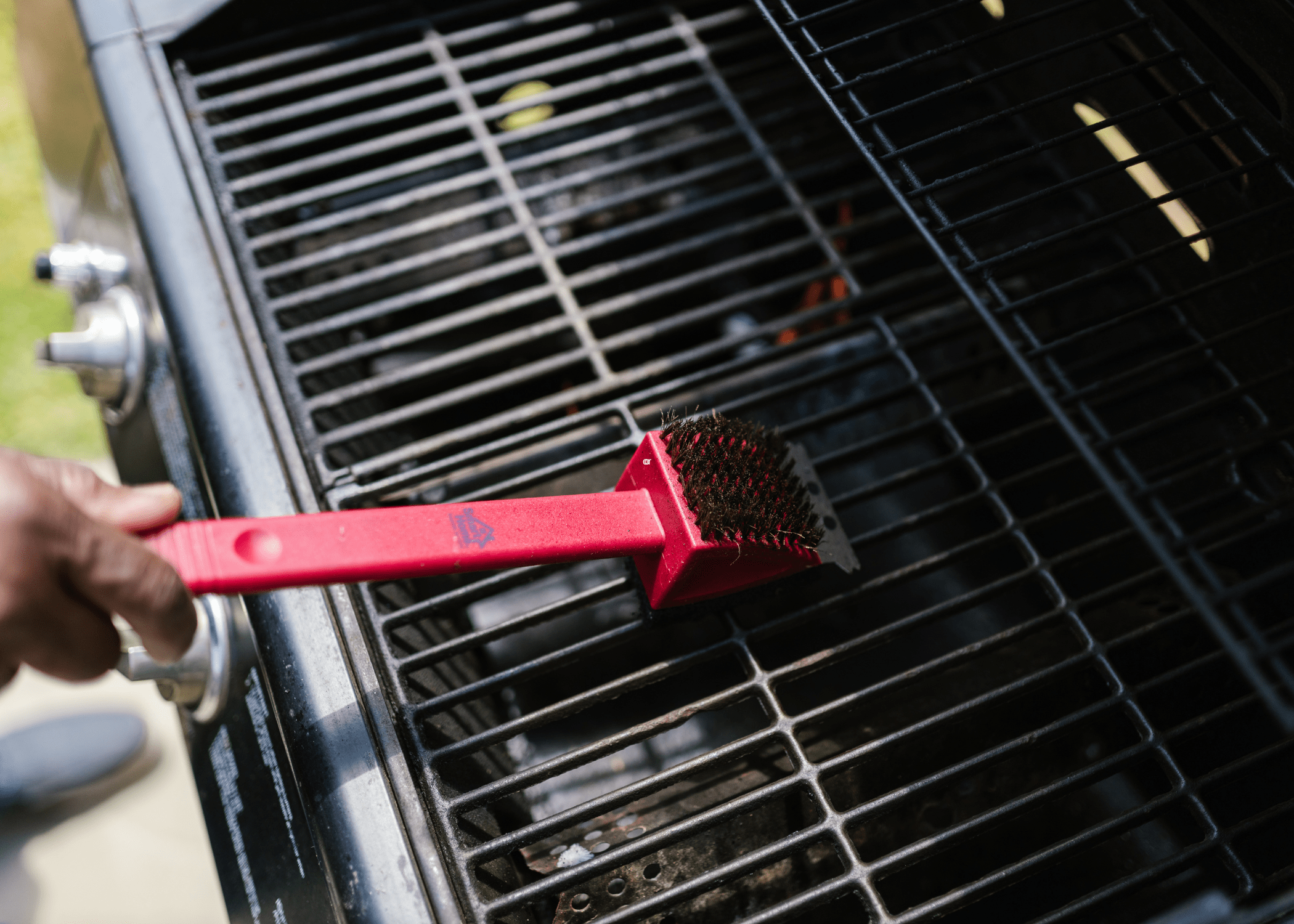 cleaning grill with scrub brush
