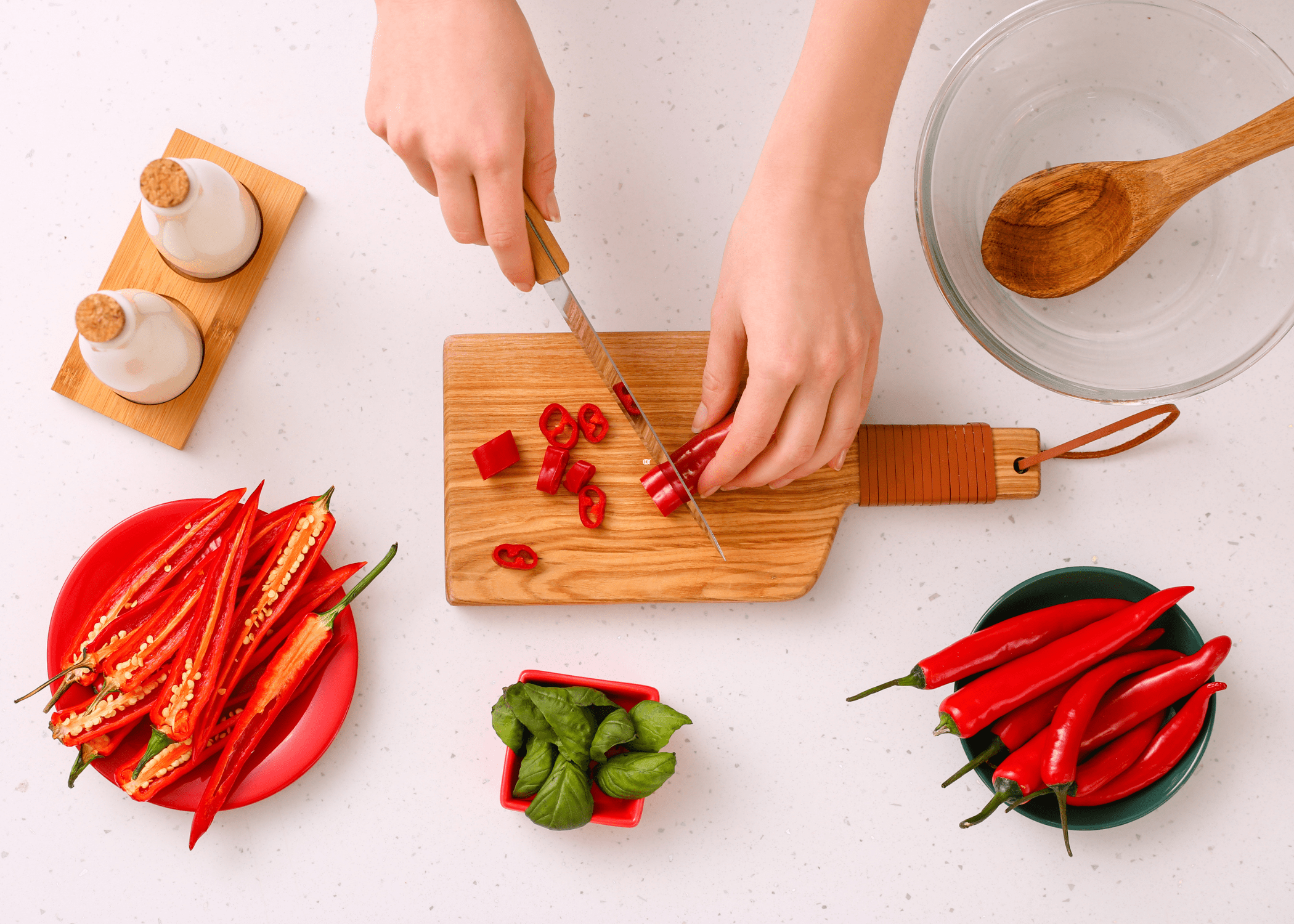 cutting red chili peppers on wood cutting board