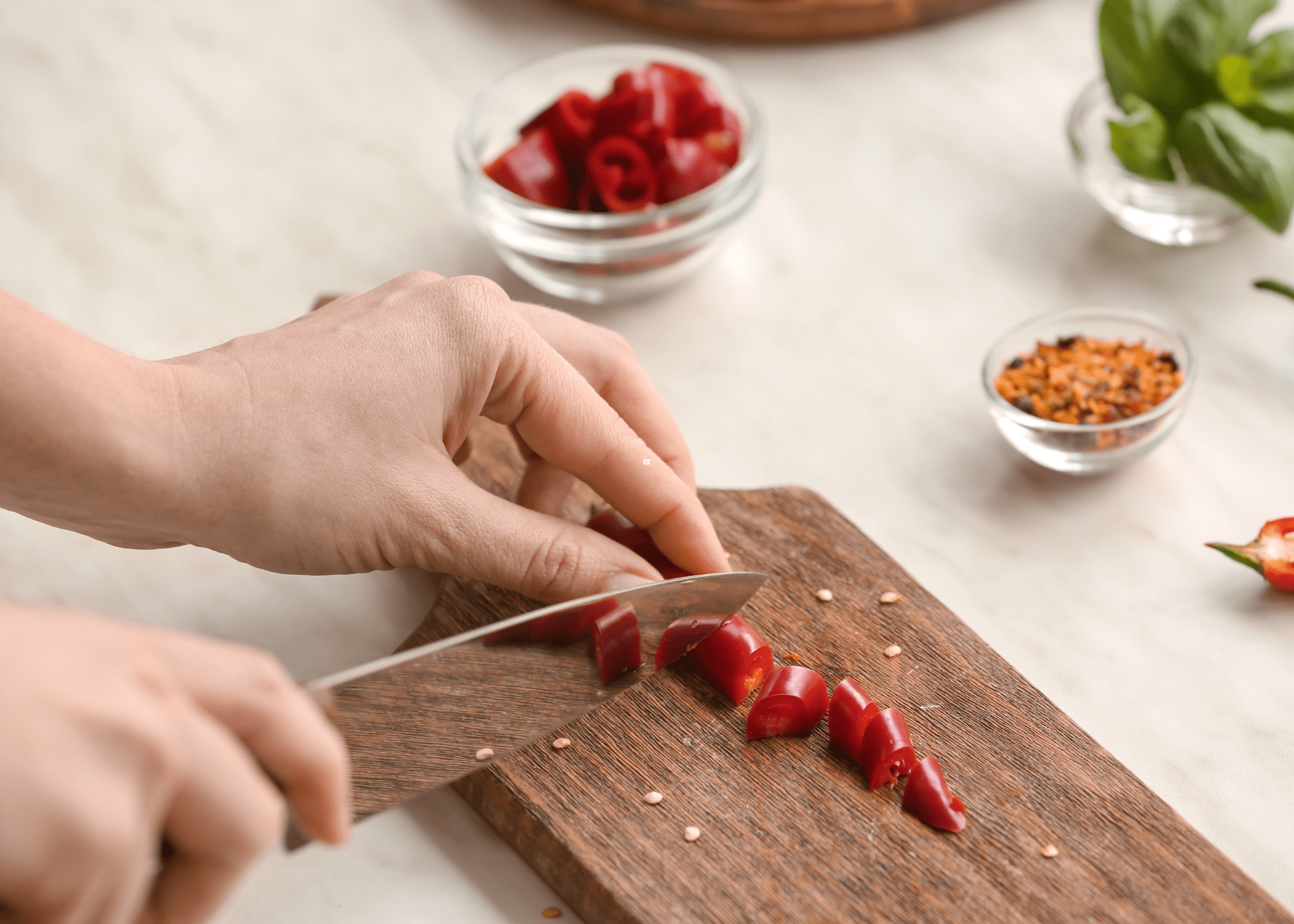 cutting red chili peppers on wood cutting board