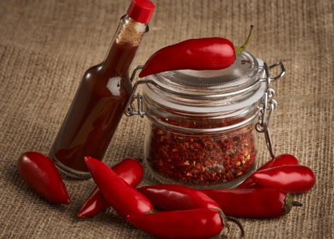 red chili peppers hot sauce and spices in jar