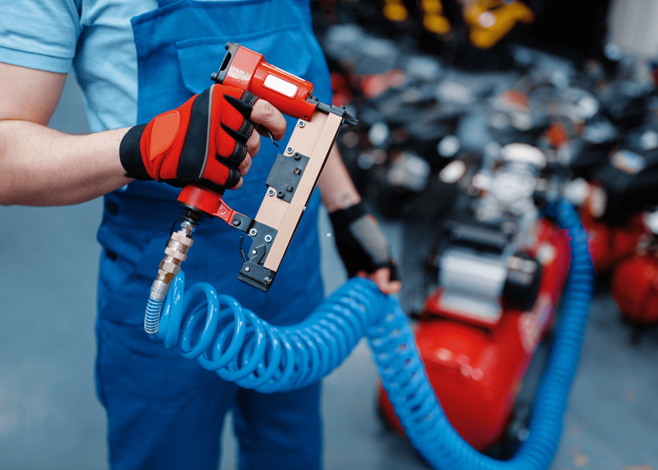 man wearing a glove holding a red pin nailer