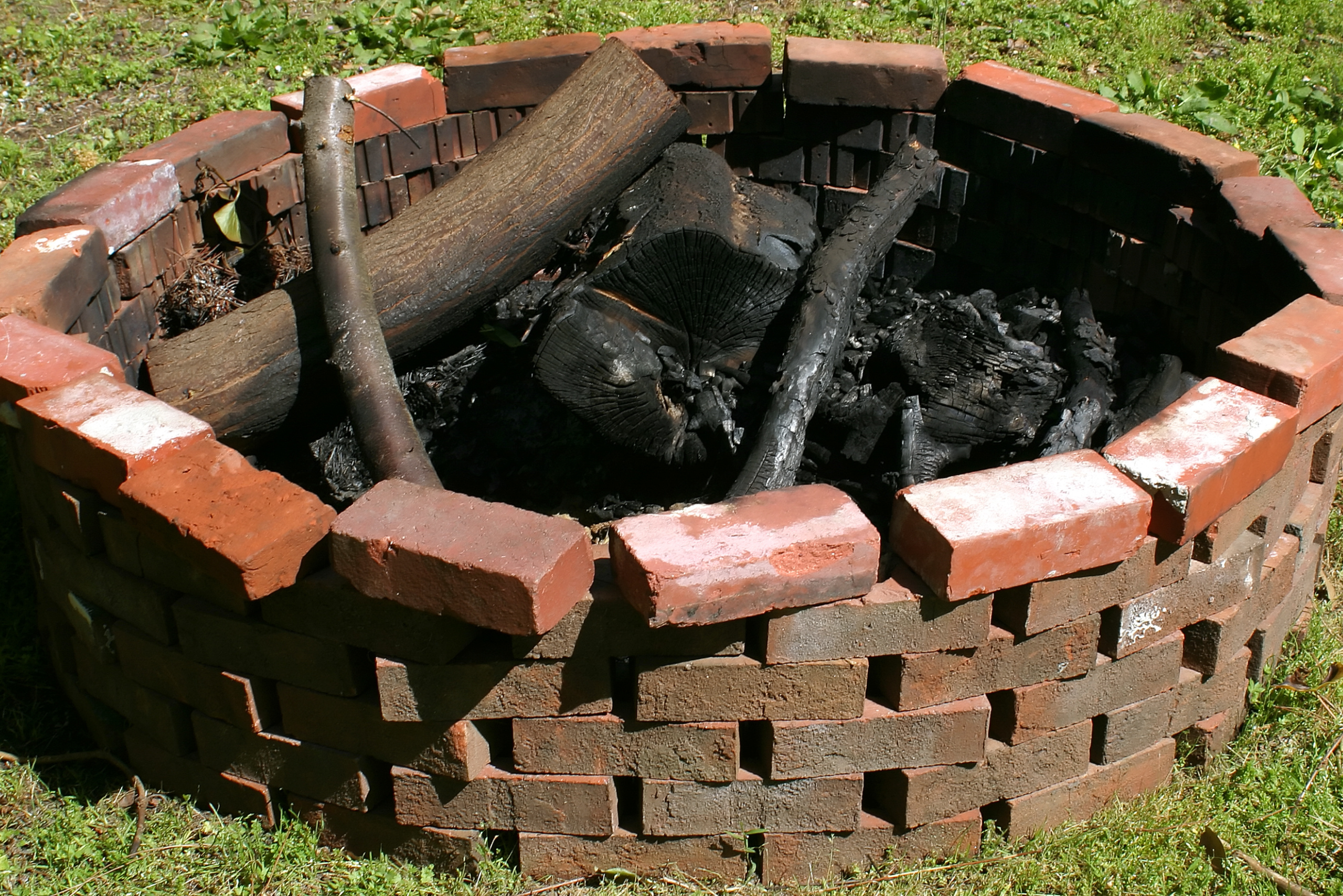DIY brick fit pit with burnt wood.