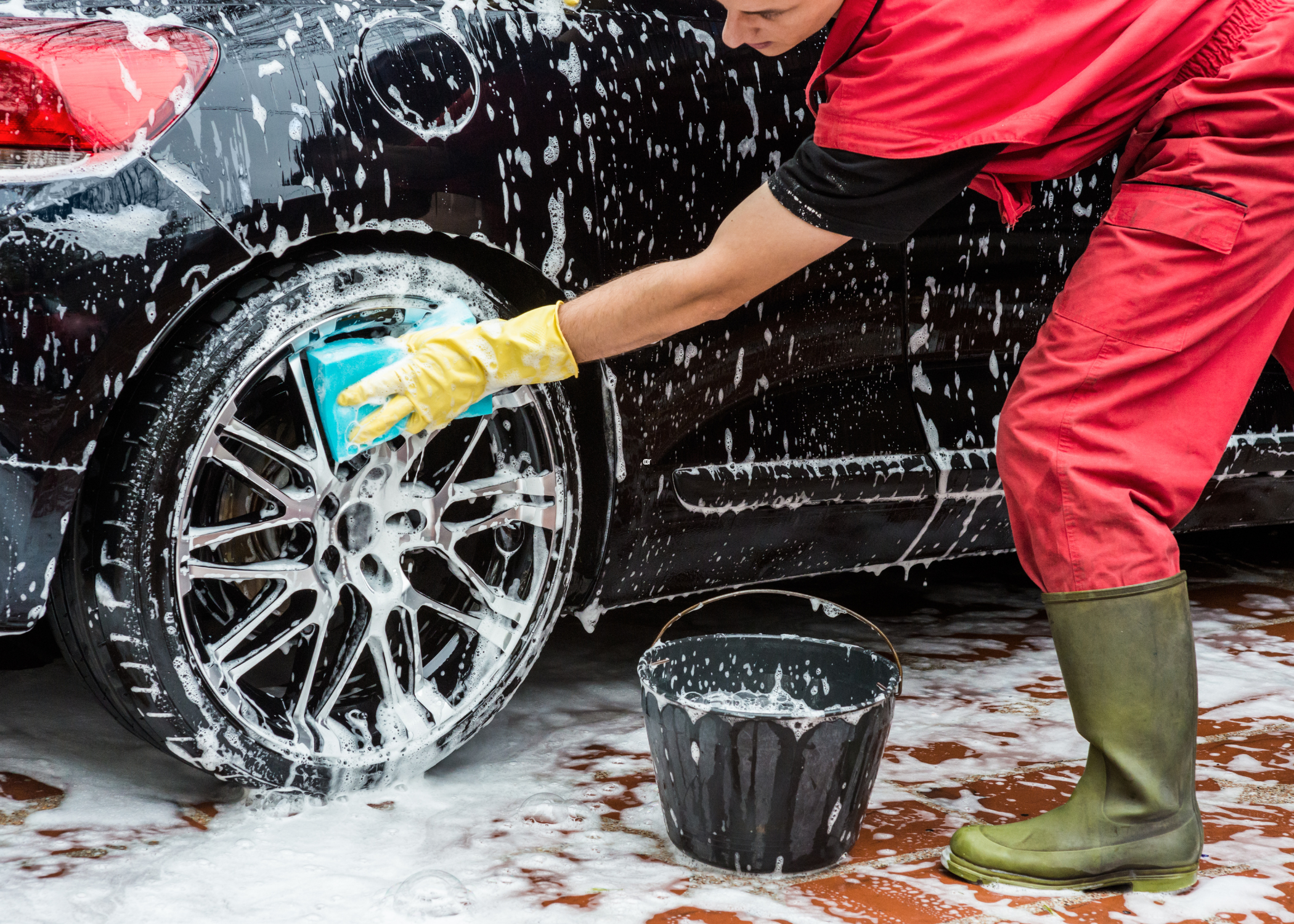 wiping down the exterior of car with soapy sponge