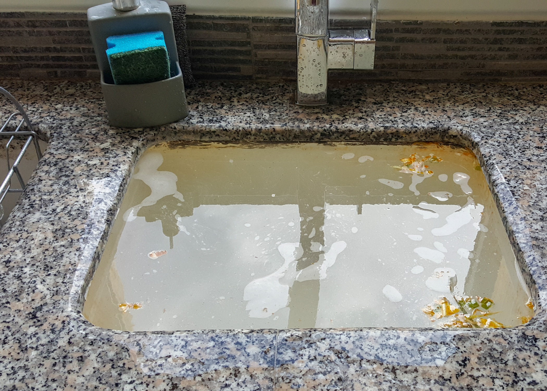 clogged sink full of dirty water