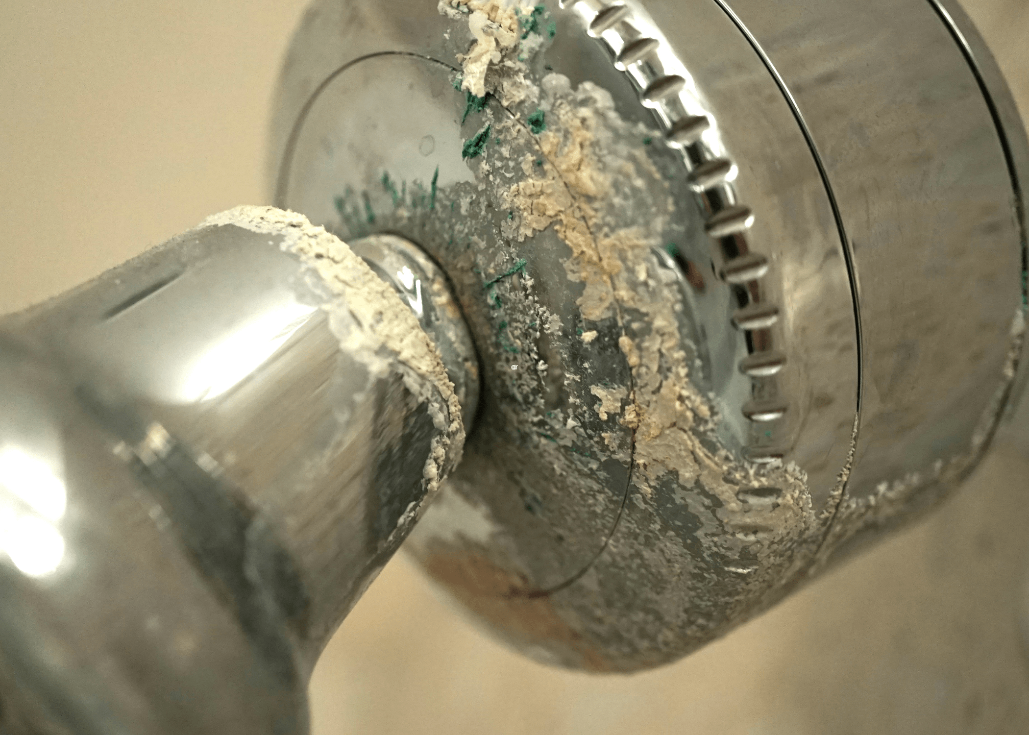 shower head close up covered in calcium and lime