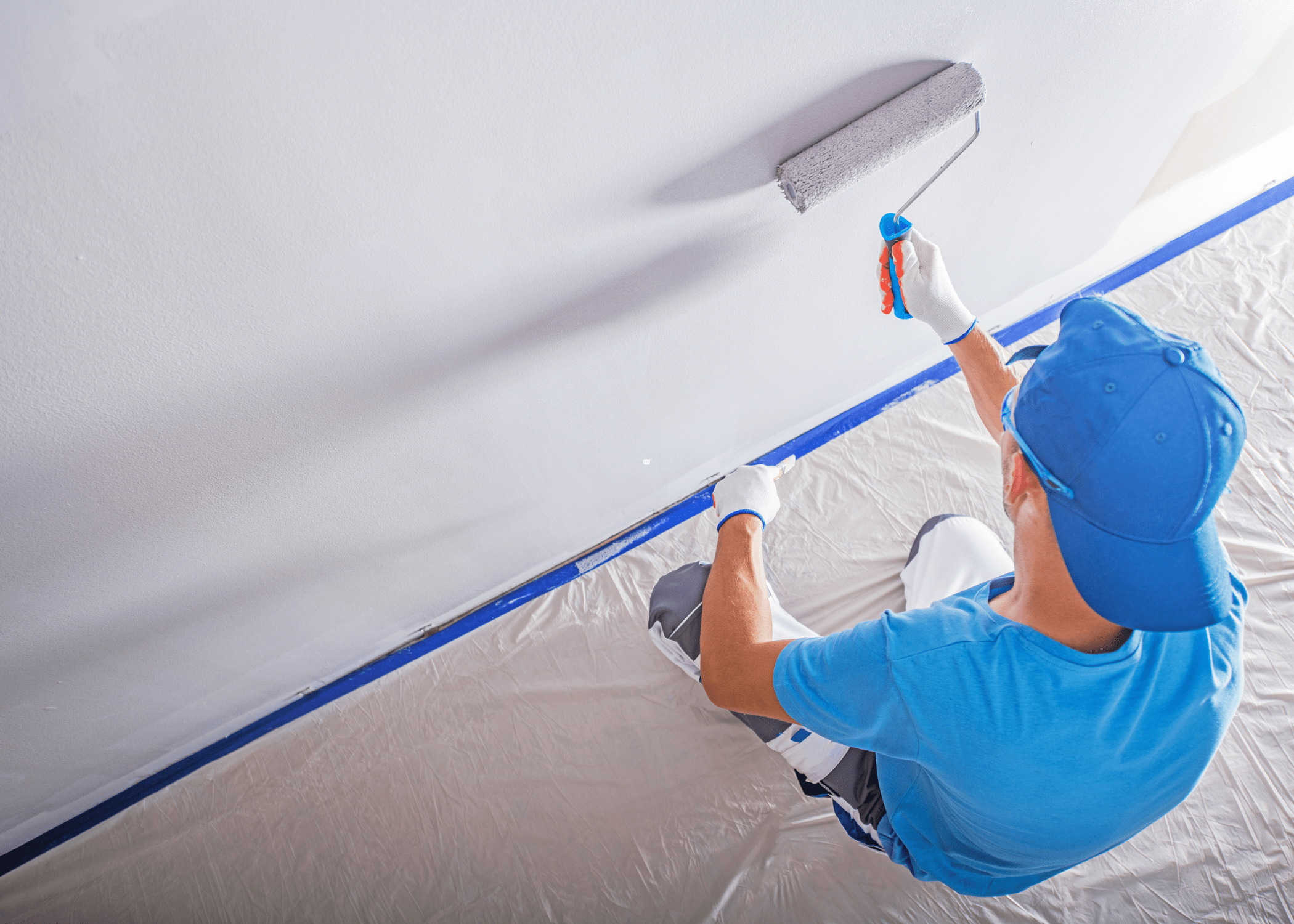 man painting a wall with a roller