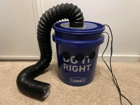 A Lowe's blue bucket with tubes and wires running into it.