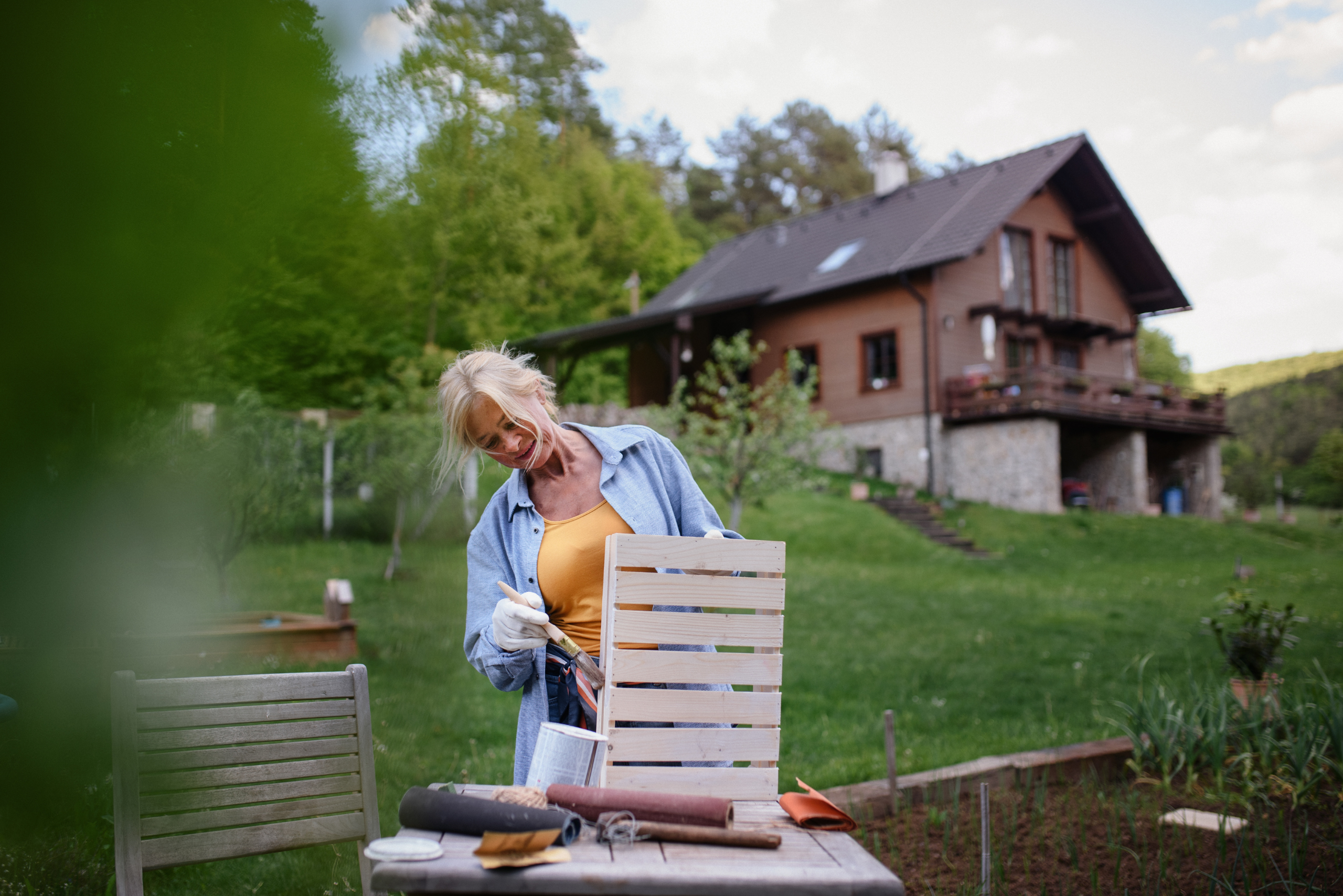 woman painting a wooden crate