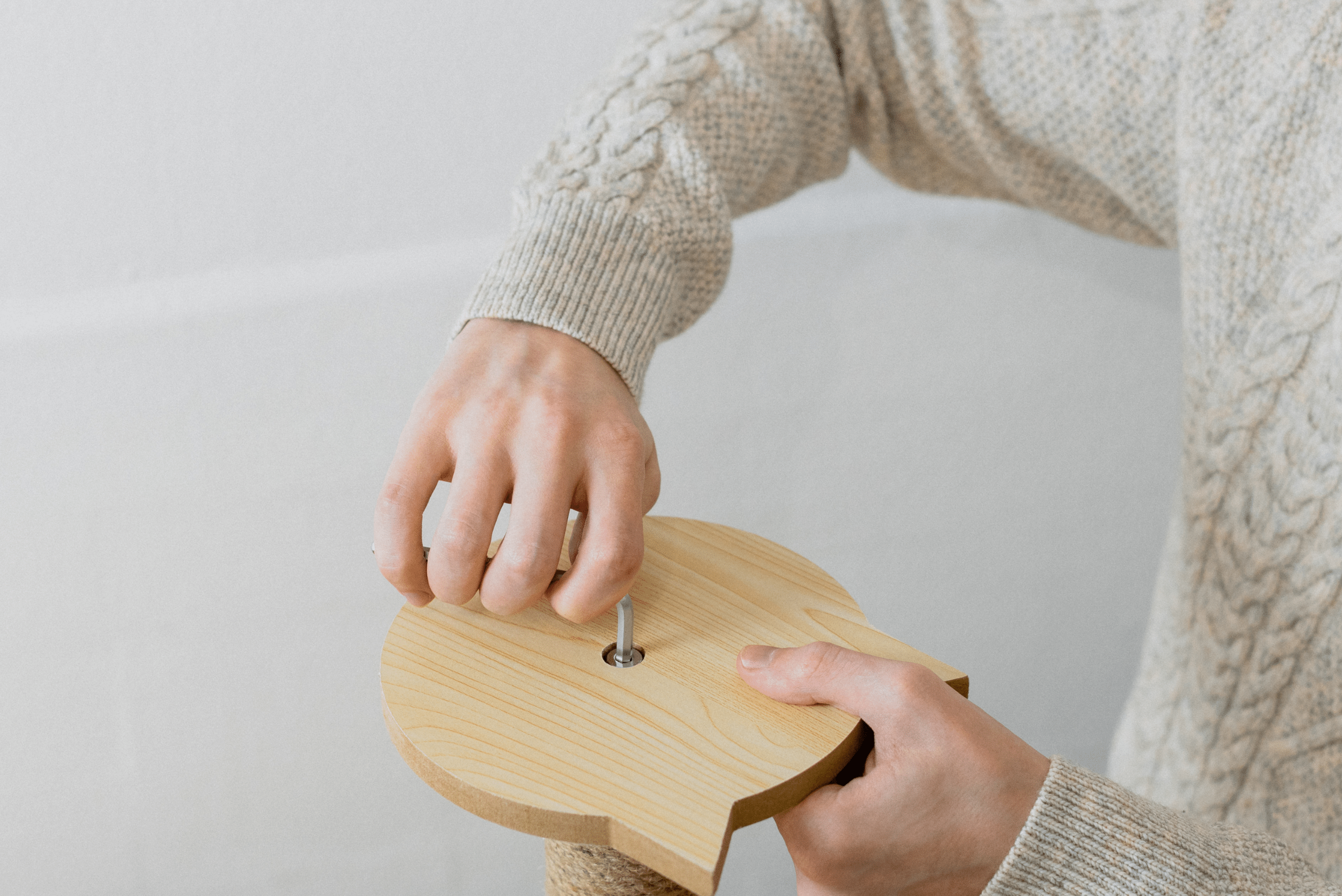 Person tightening the top of a cat scratching post.