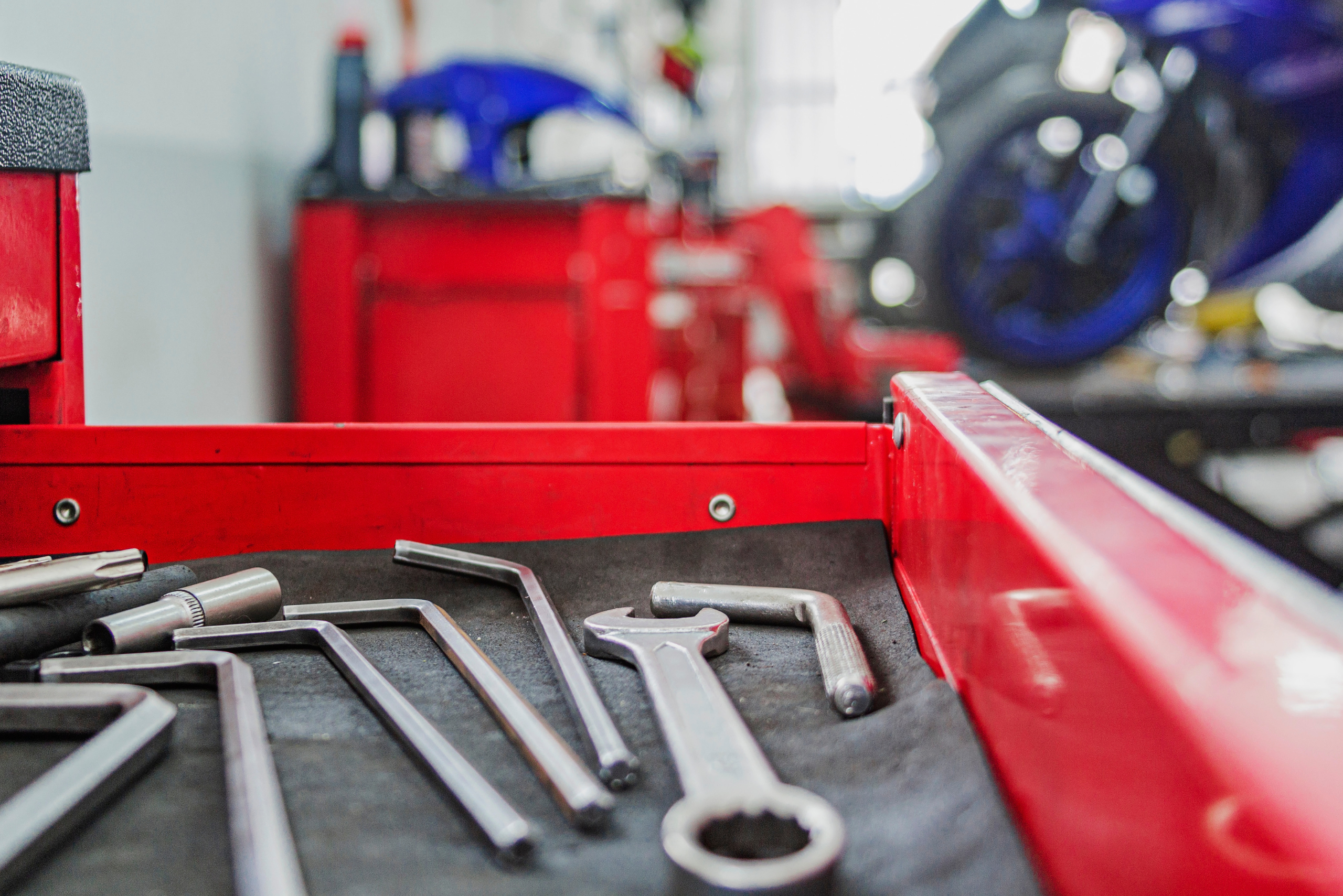 Red mechanic box with tools inside its drawer.