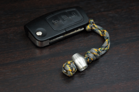 A car key attached to a paracord keychain.
