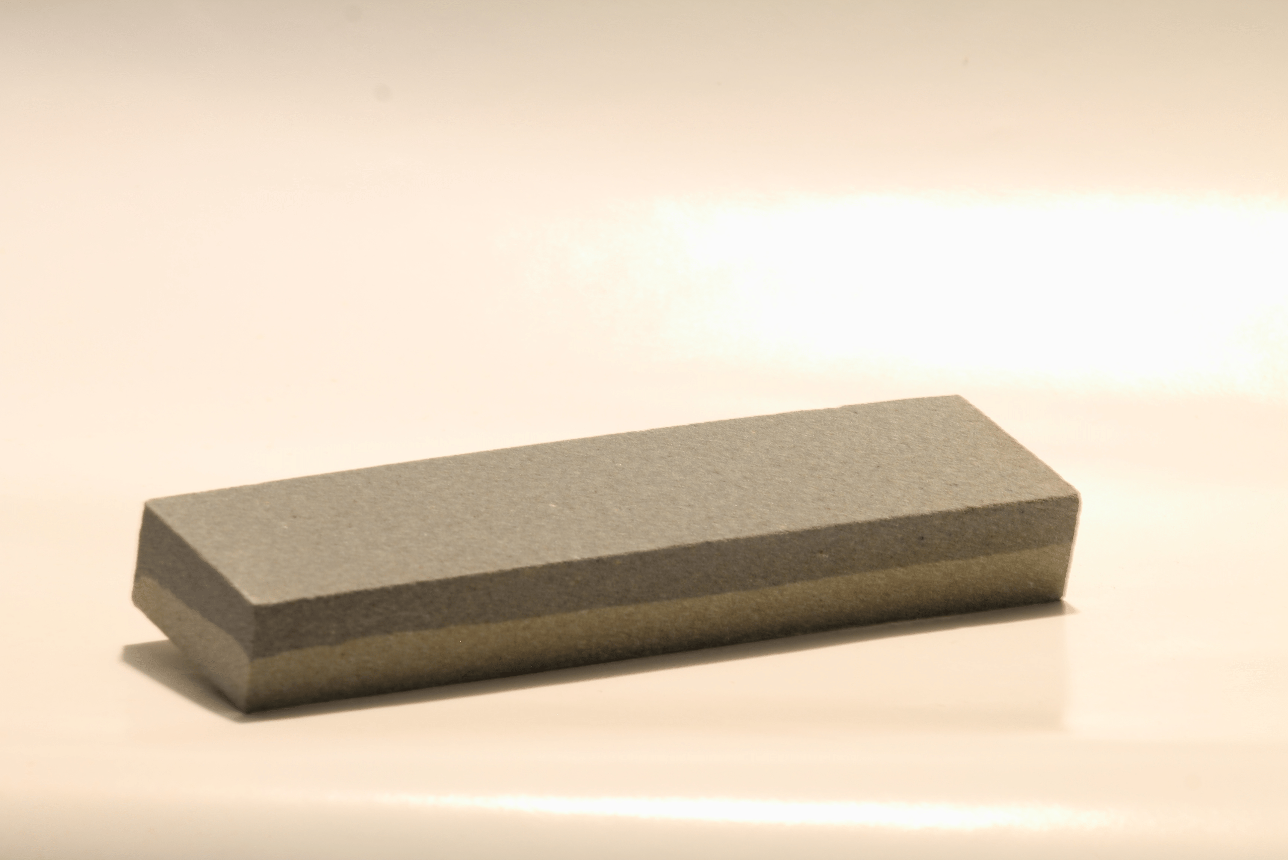 Sharpening stone on wood background.