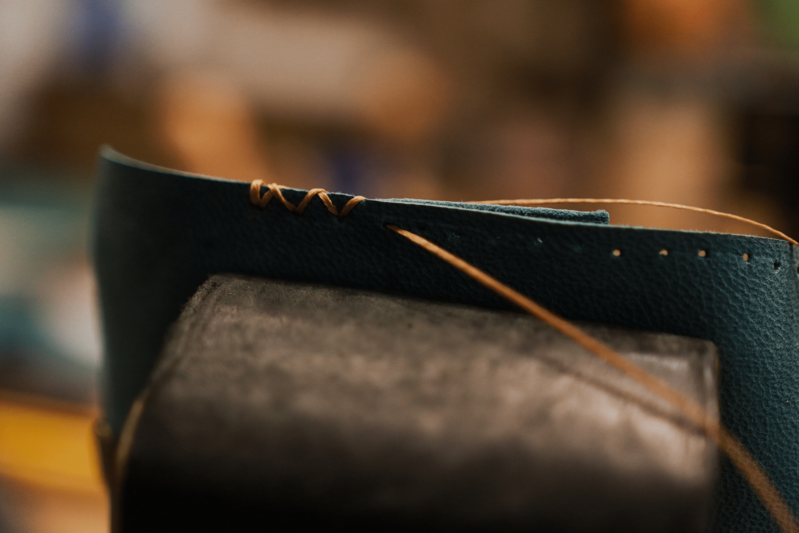 A leather wallet being stitched together.