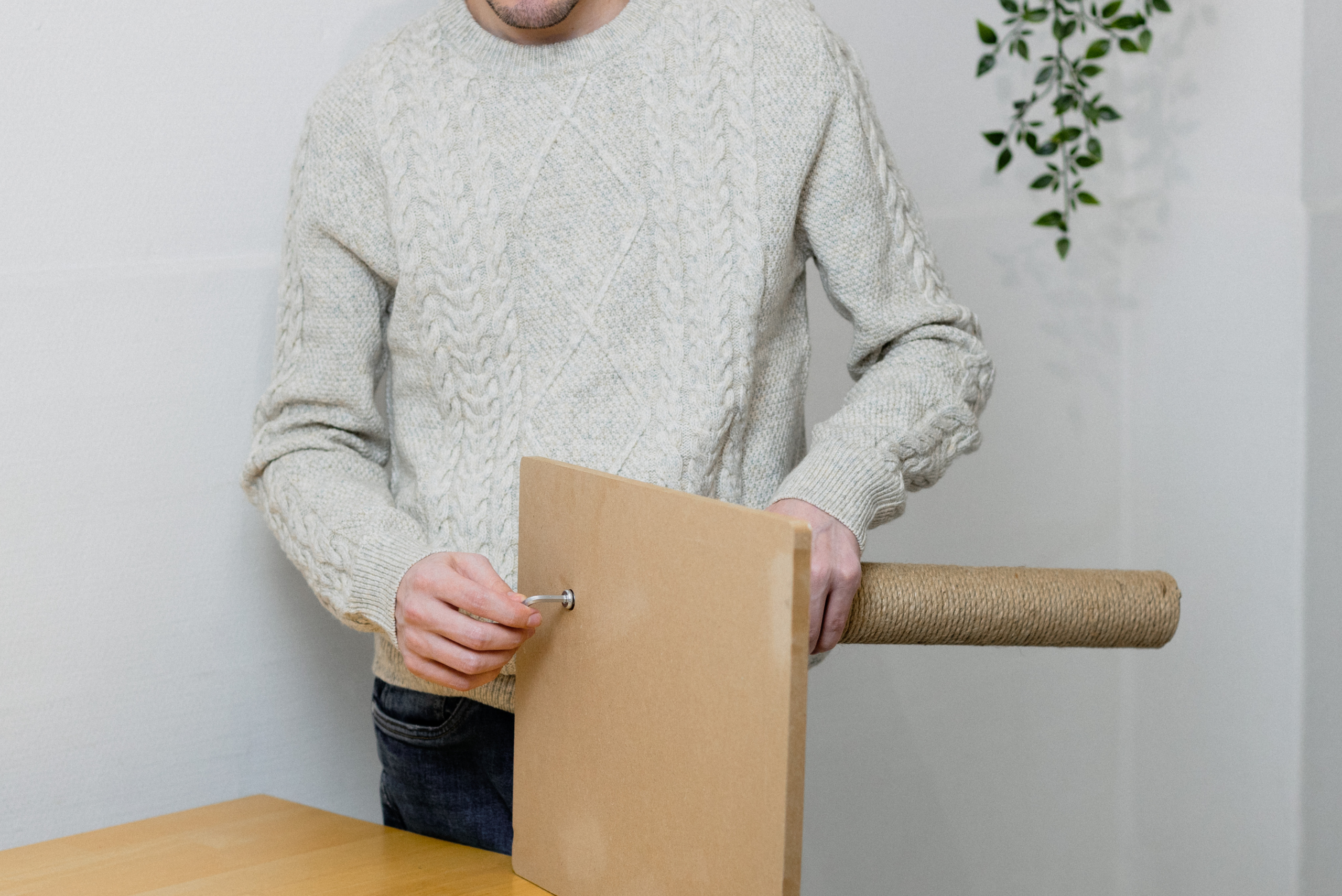 Person tightening the base of a scratching post.