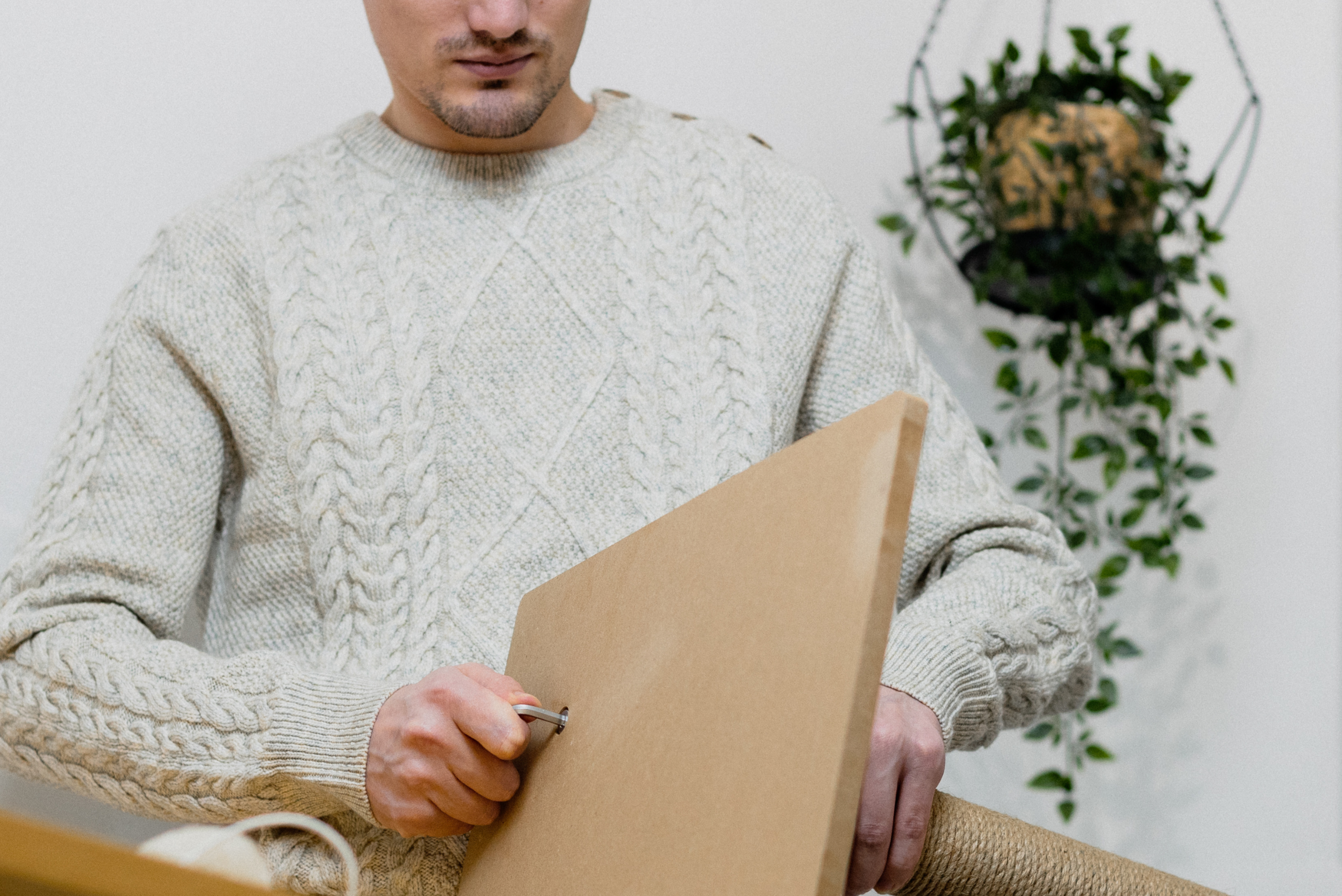 Person tightening the base of a scratching post.