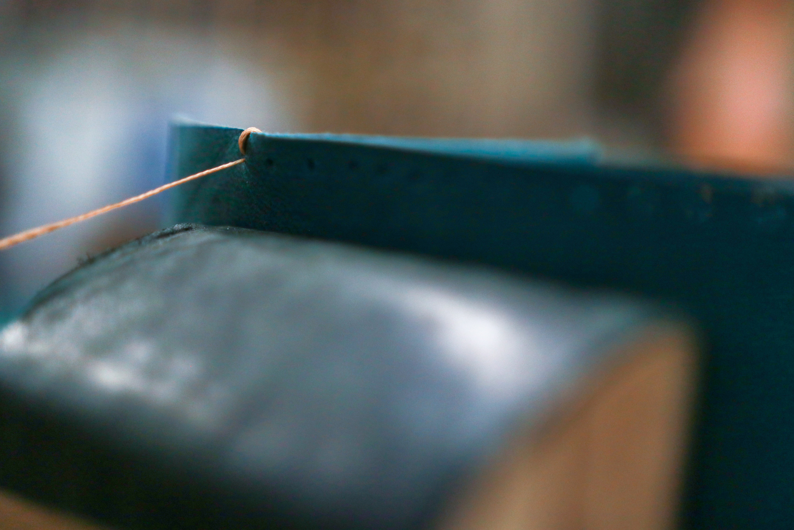 A leather wallet being stitched together.