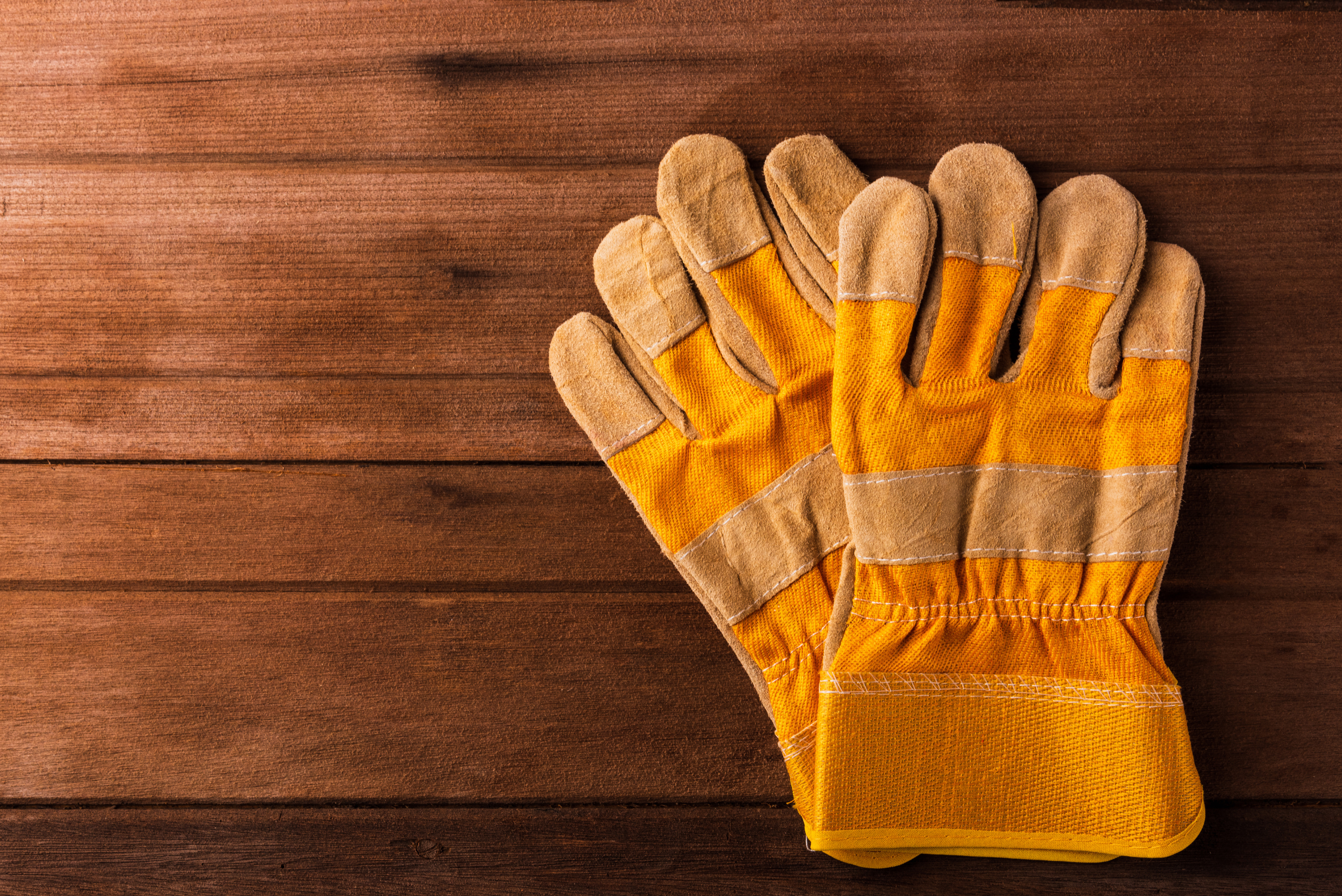 A pair of work gloves on a wooden table.