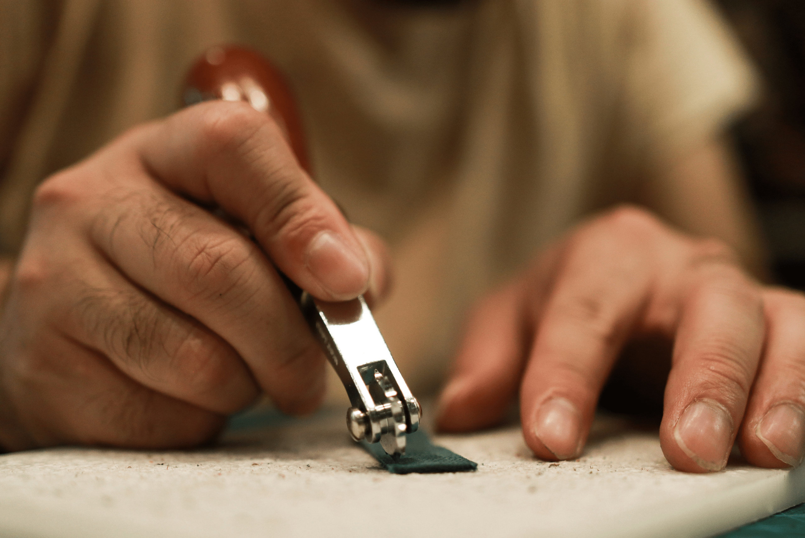 Person cutting leather for wallet.