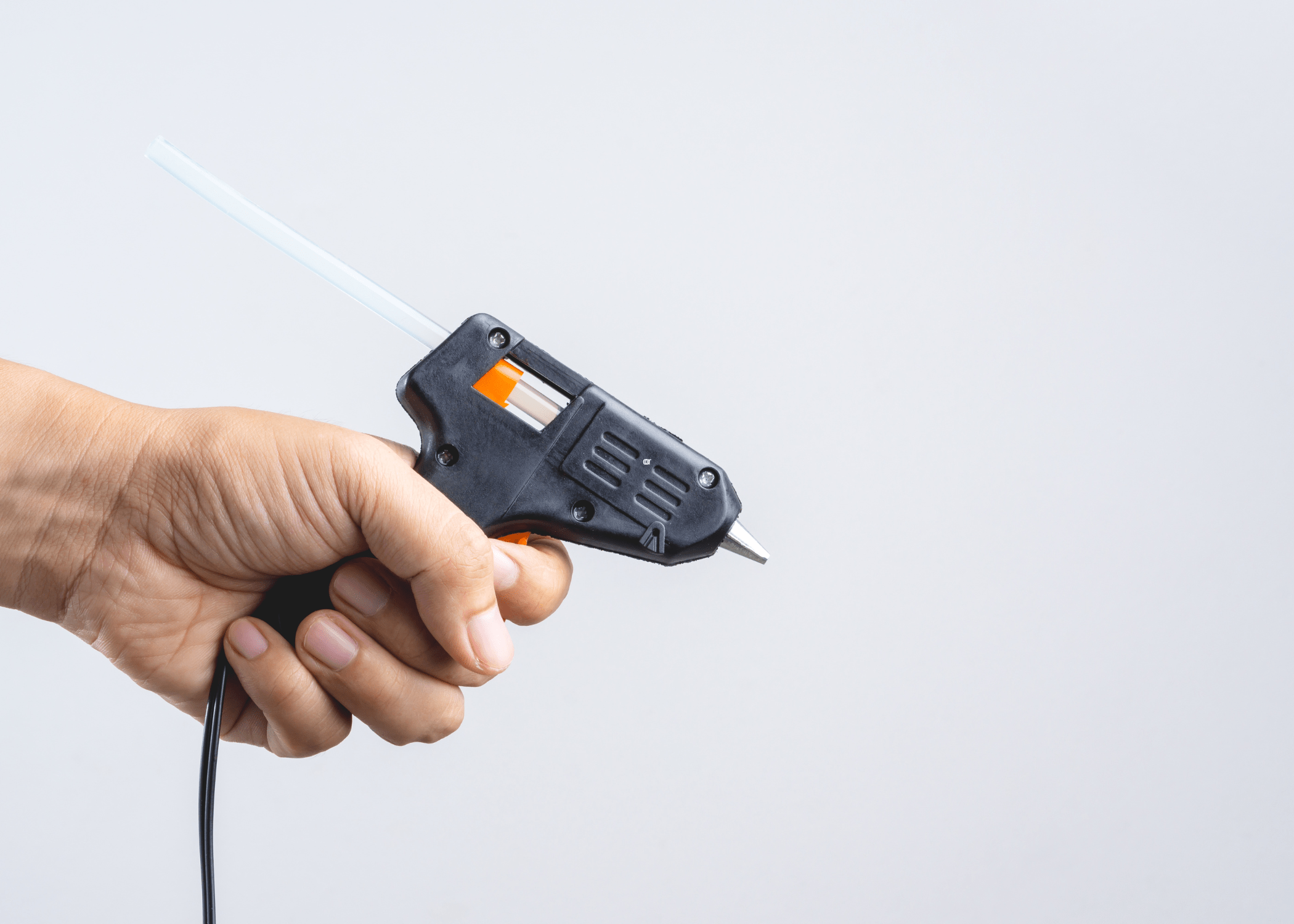 hand holding a black hot glue gun