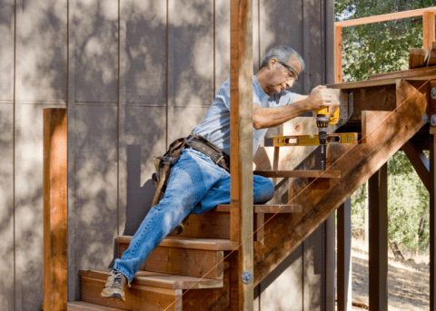 building deck stairs man with a power drill