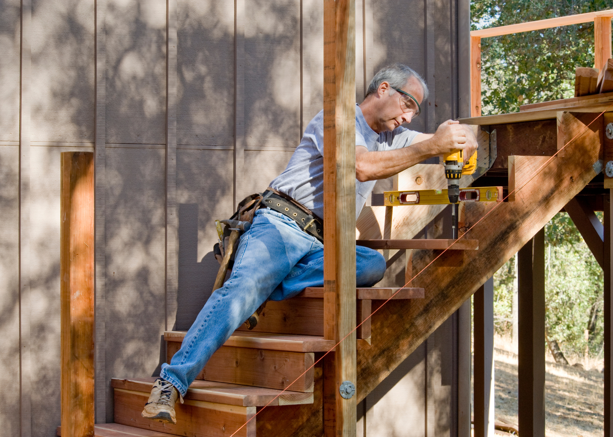 building deck stairs man with a power drill