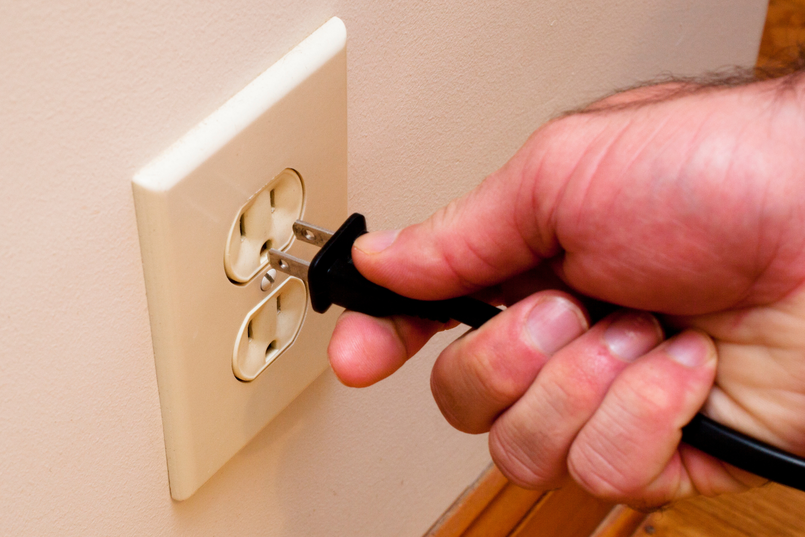 Plugging a black plug into a 15-amp outlet.