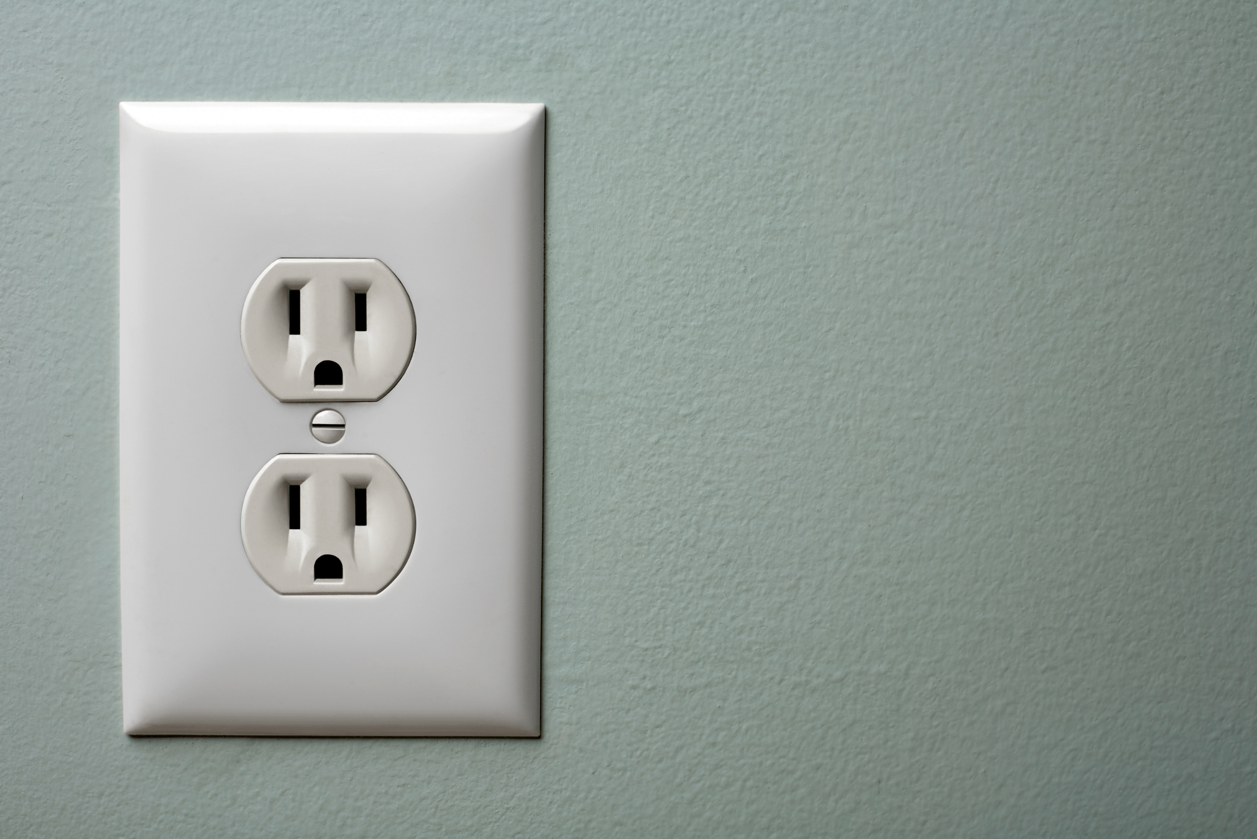 15-amp outlet with sage green wall.