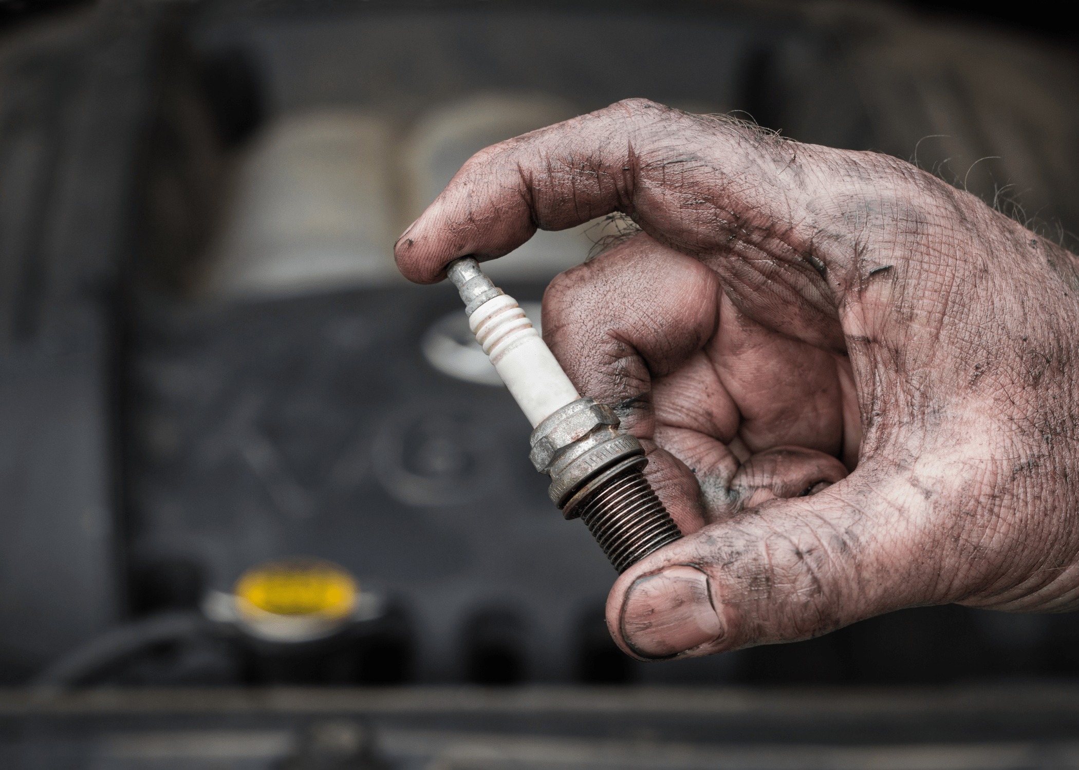 spark plug in a dirty hand