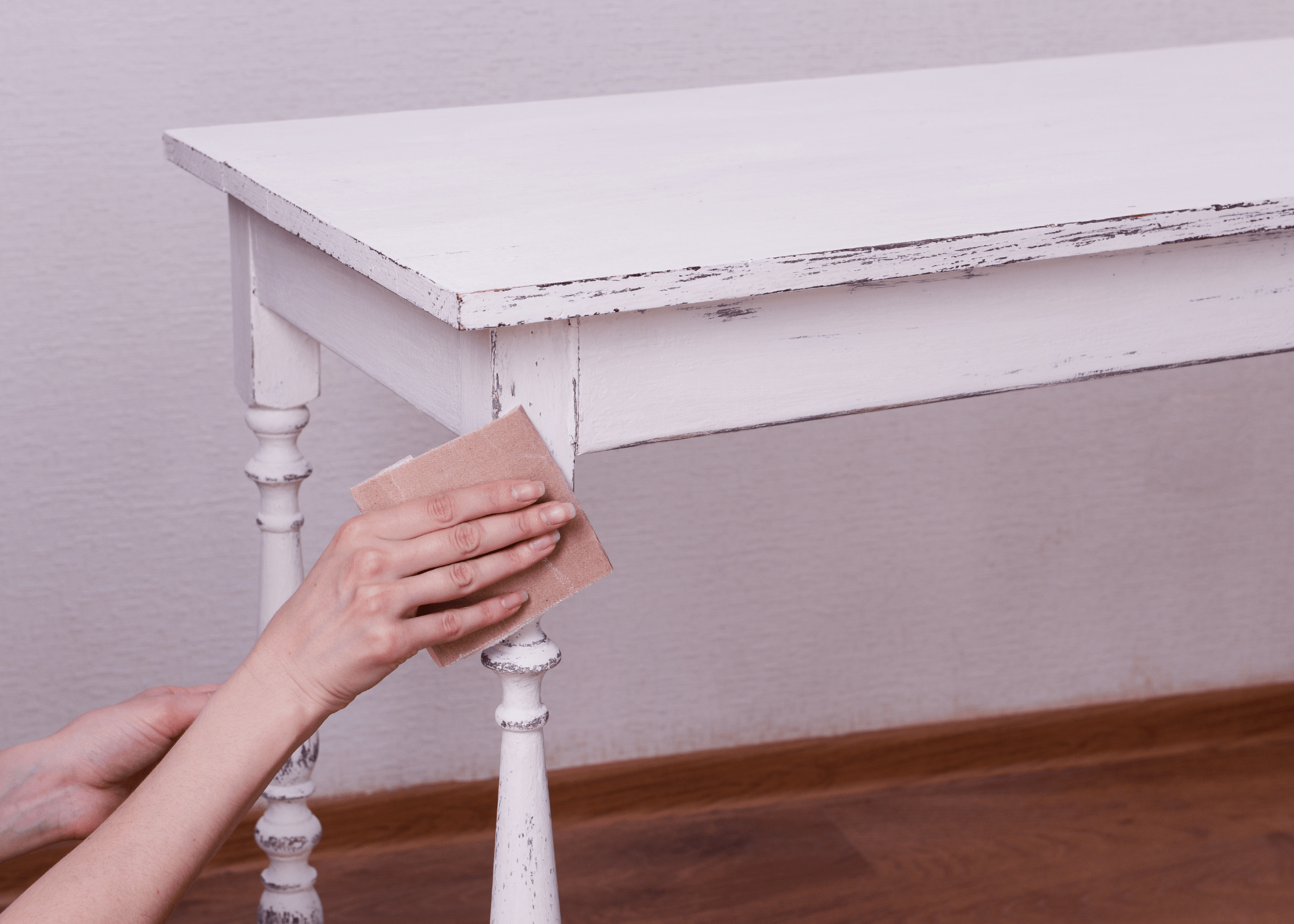 sanding down piece of distressed furniture.