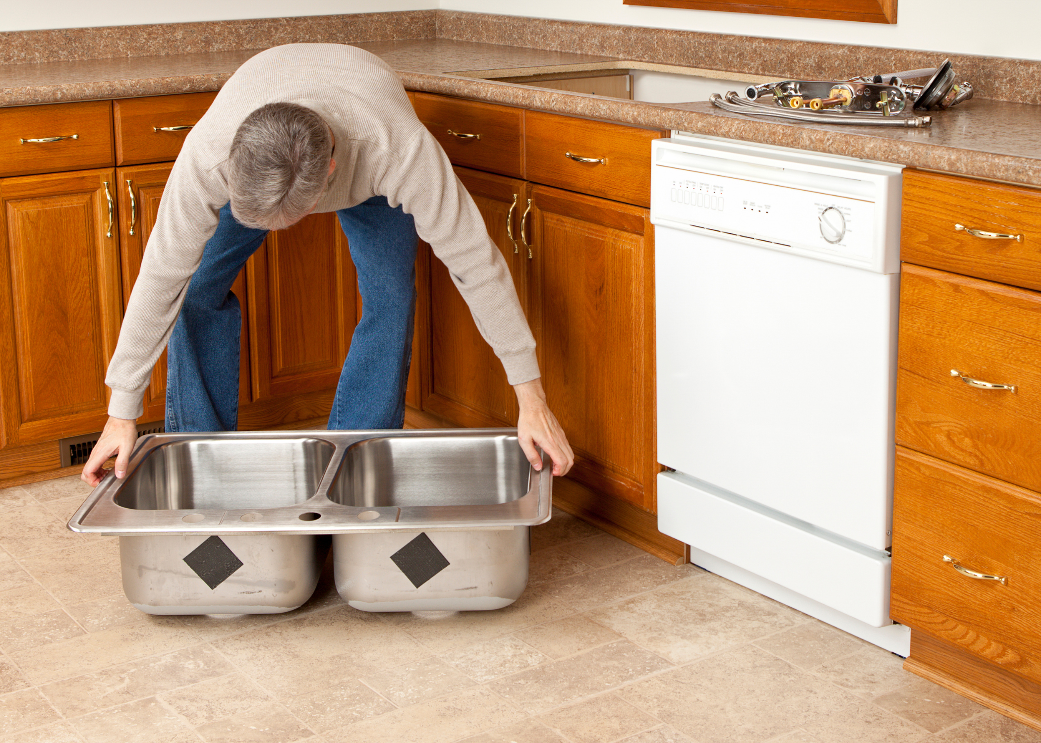 man lifting stainless steel sink