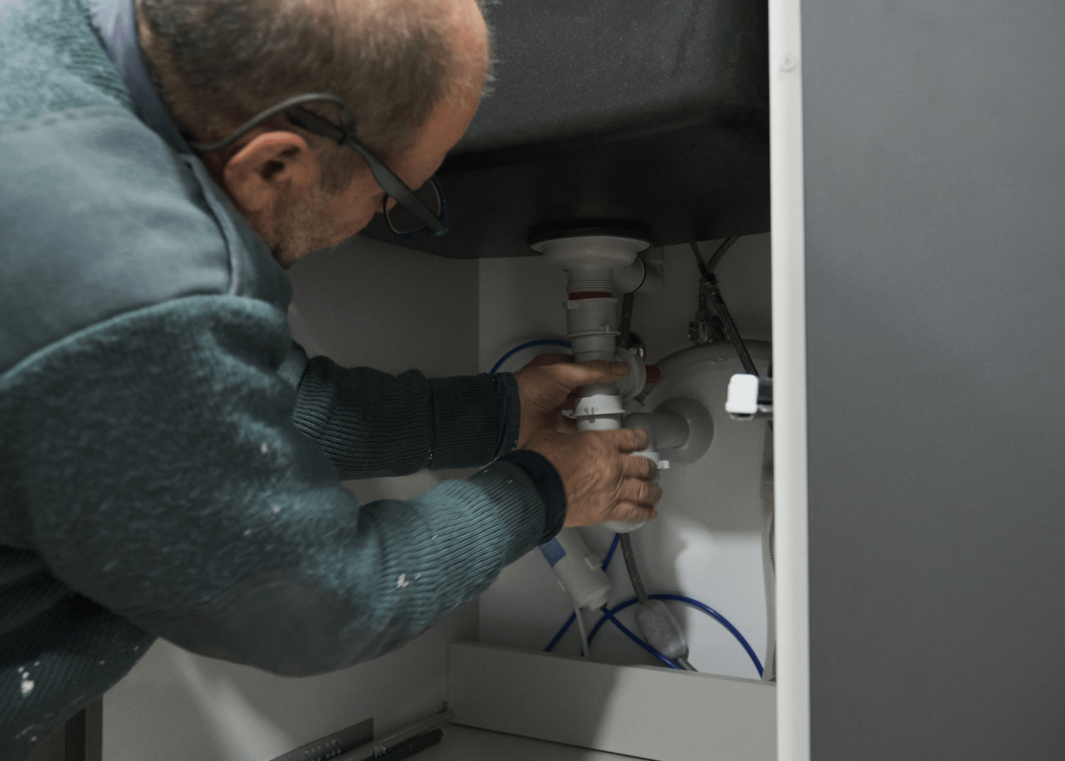 man working on sink plumbing