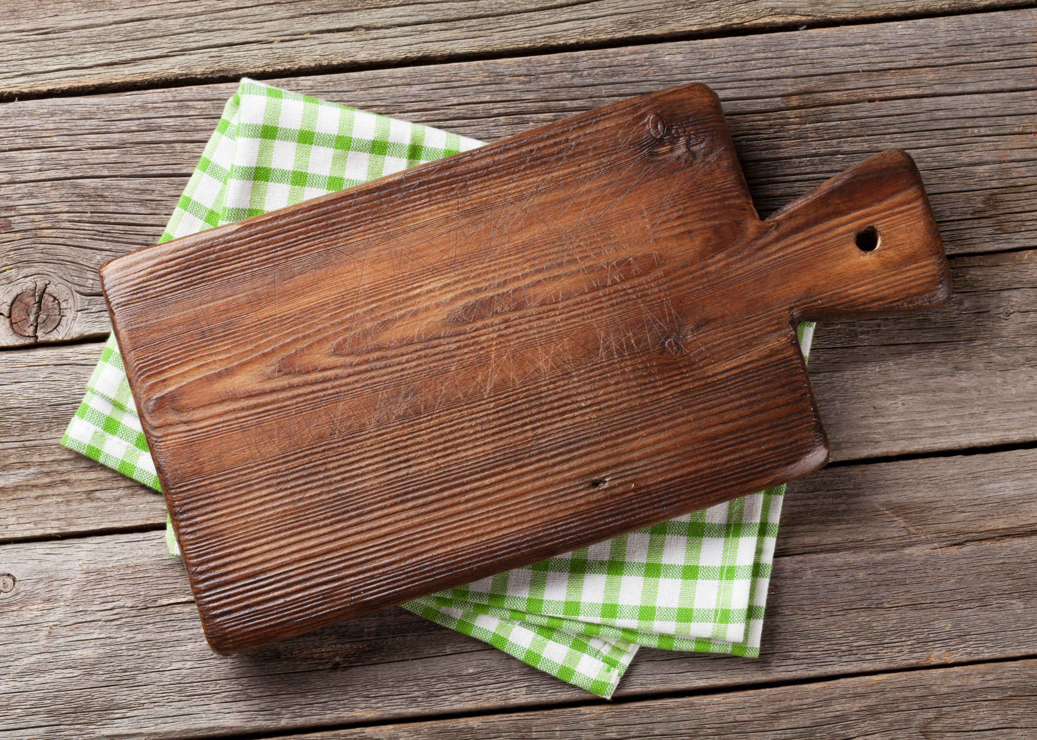 wood cutting board on tea towel on wood background