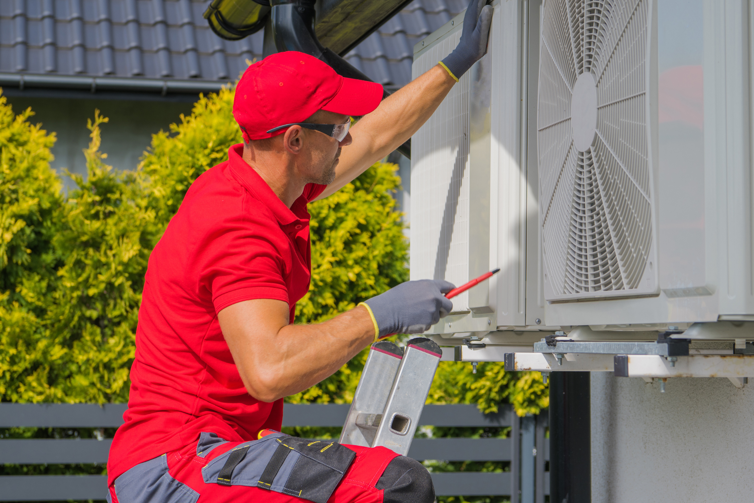 HVAC person inspecting a unit from the outside.