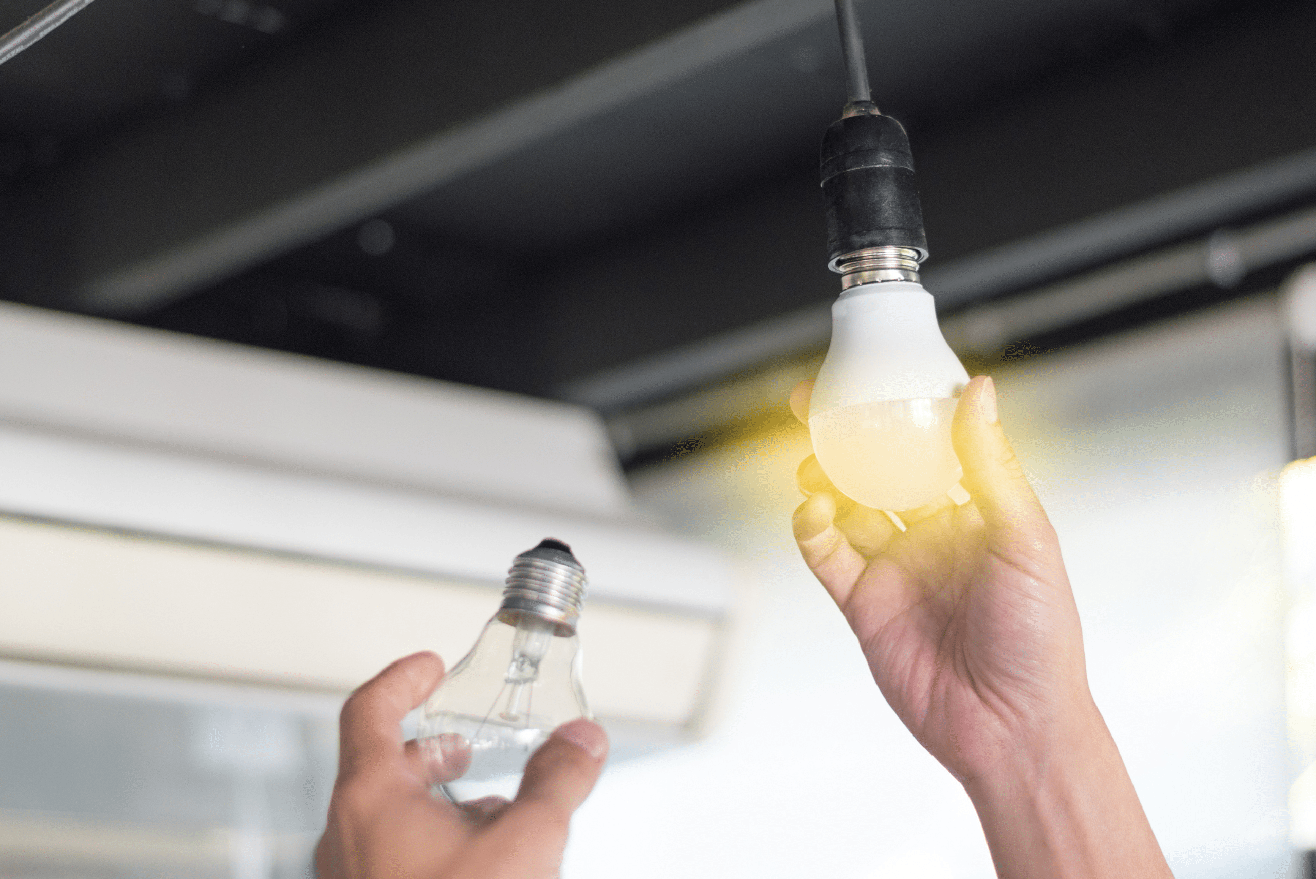 Incandescent bulb being replaced by LED bulb.