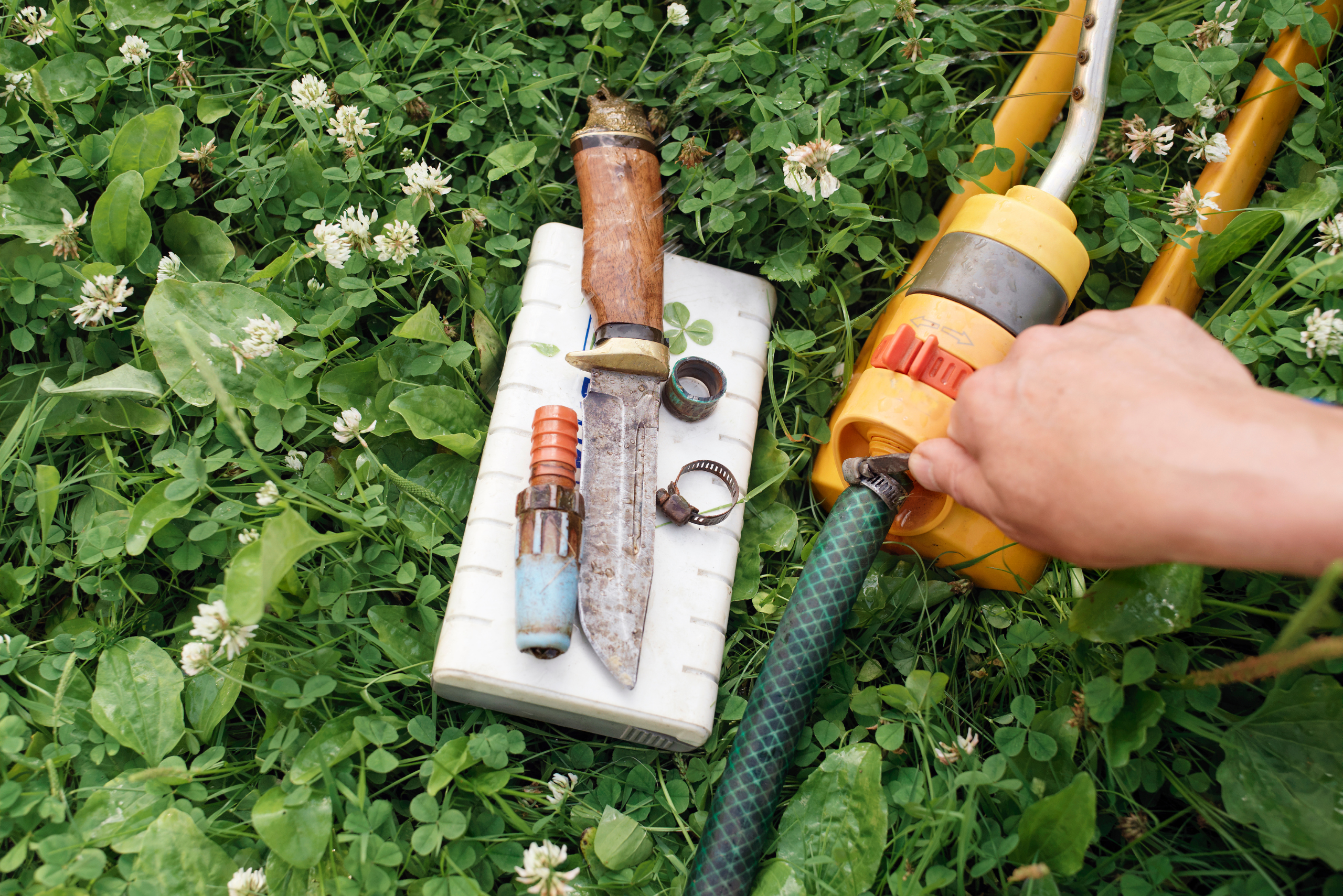 Hand repairing garden hose.