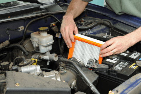 Person installing new engine air filter.