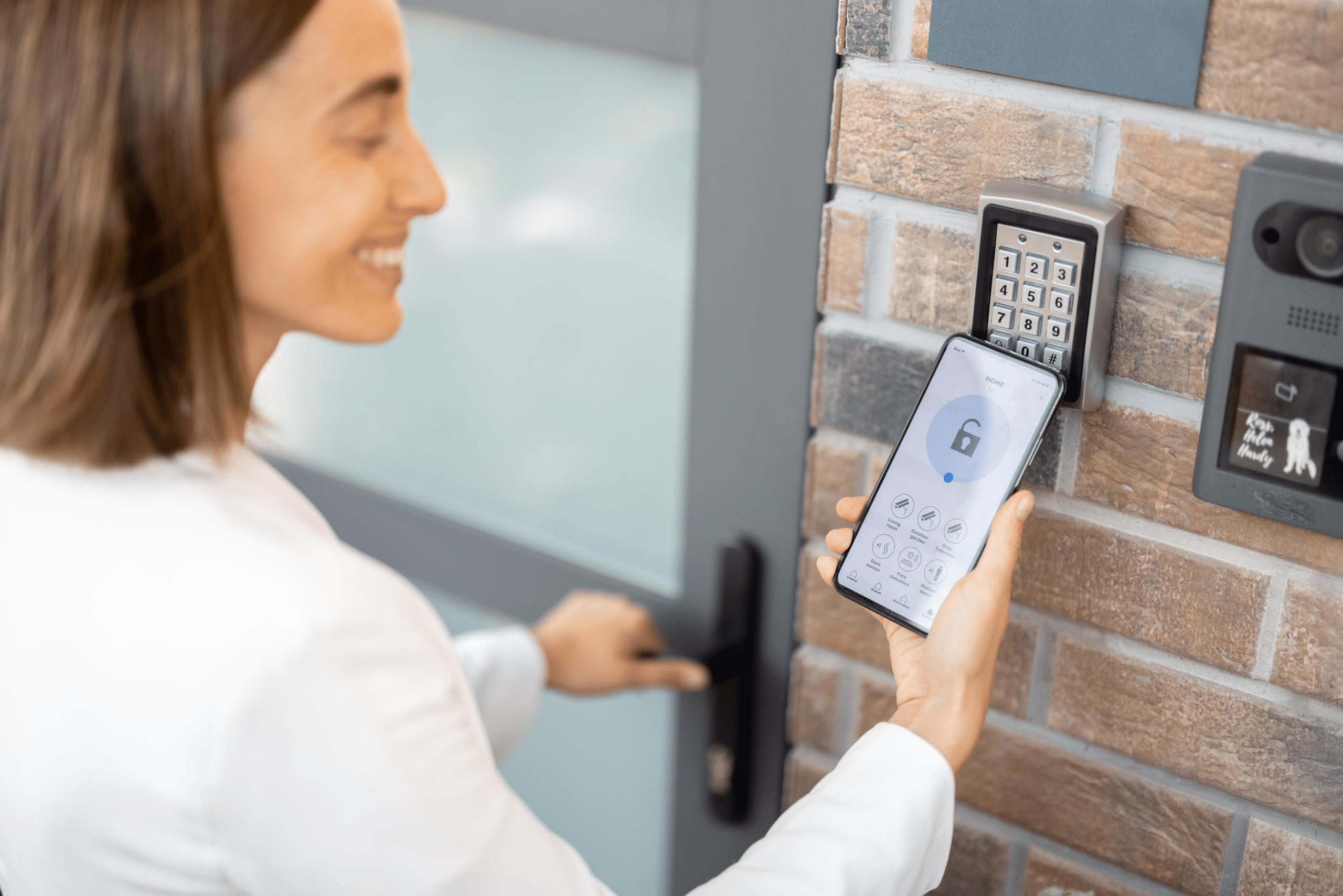 Woman using smartphone to open house door.