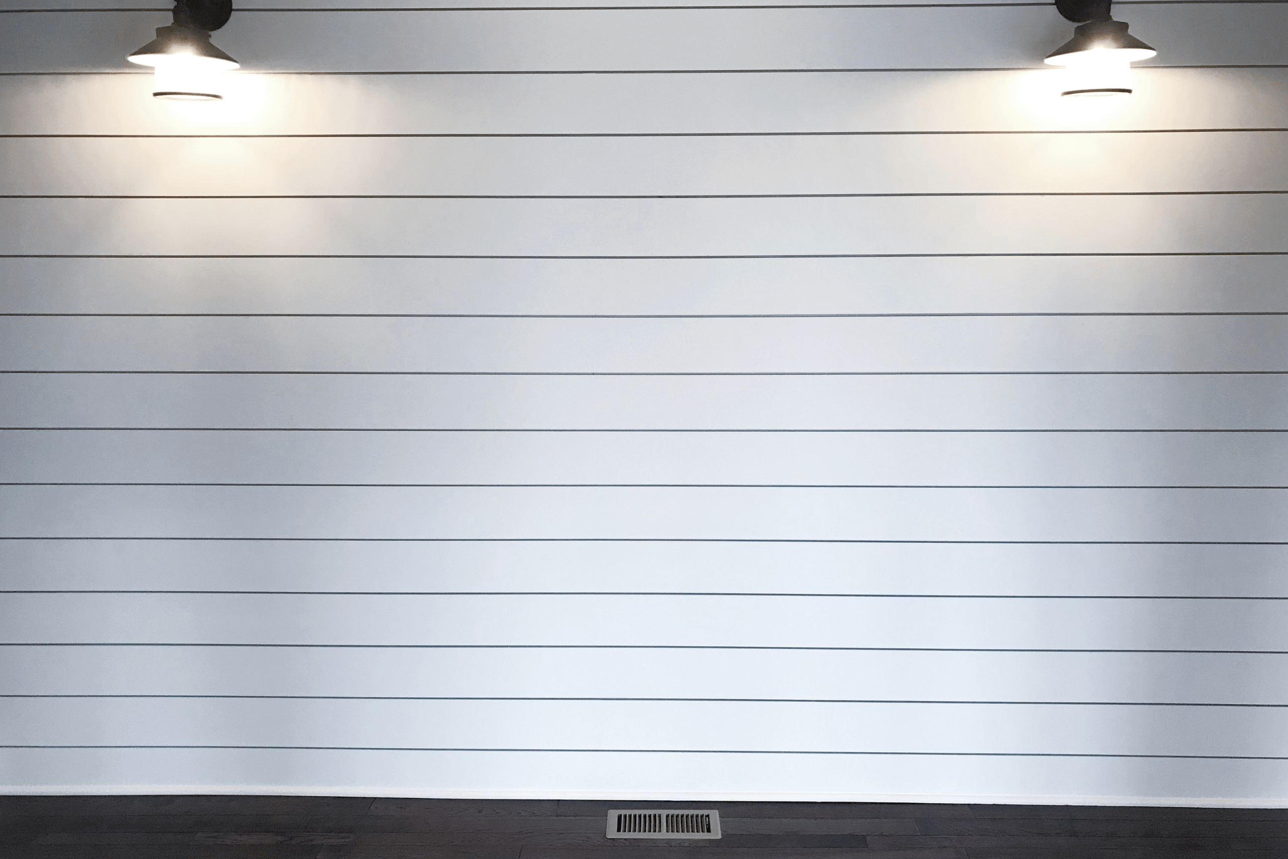 White shiplap wall with lights.