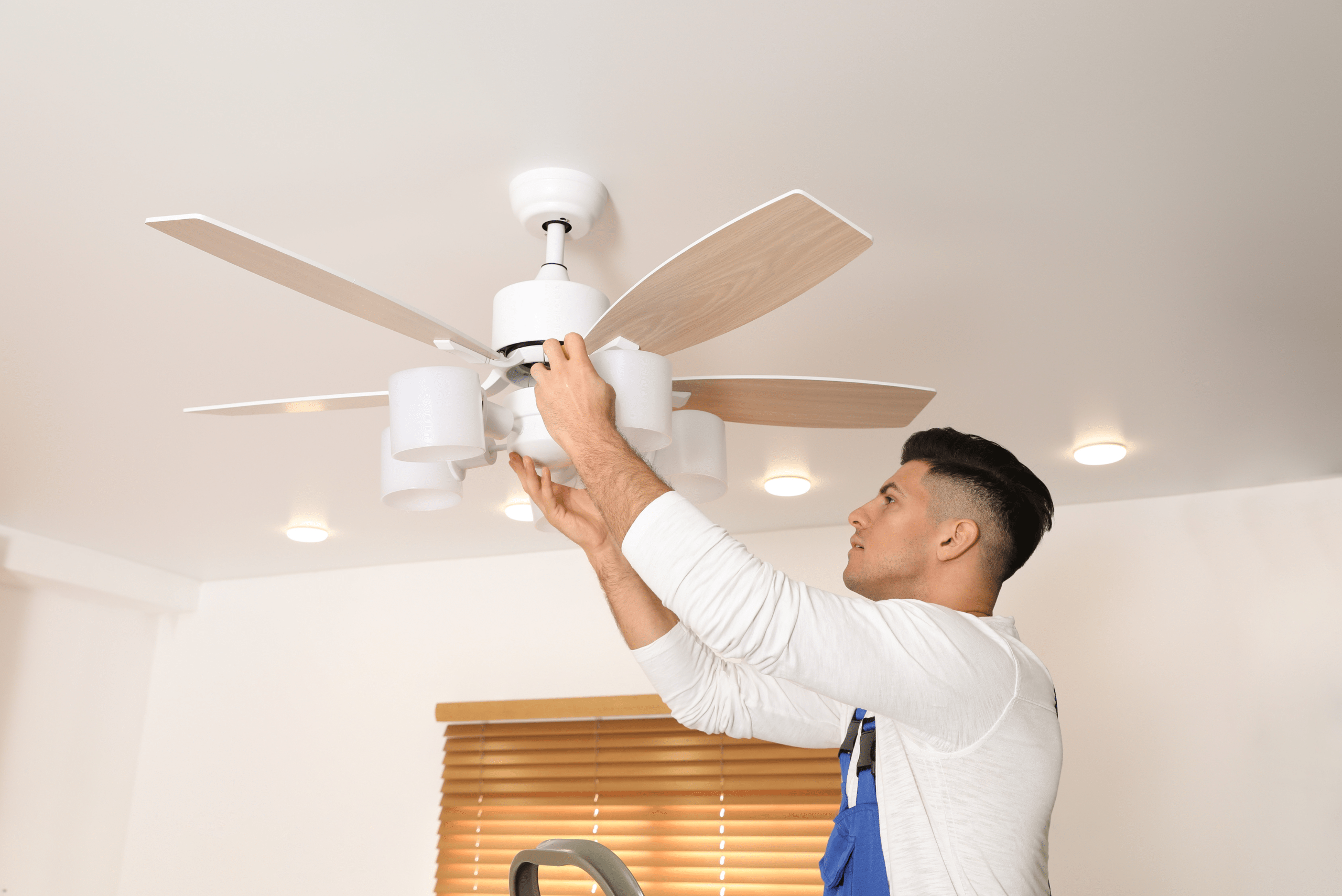 Worker installing ceiling fan.