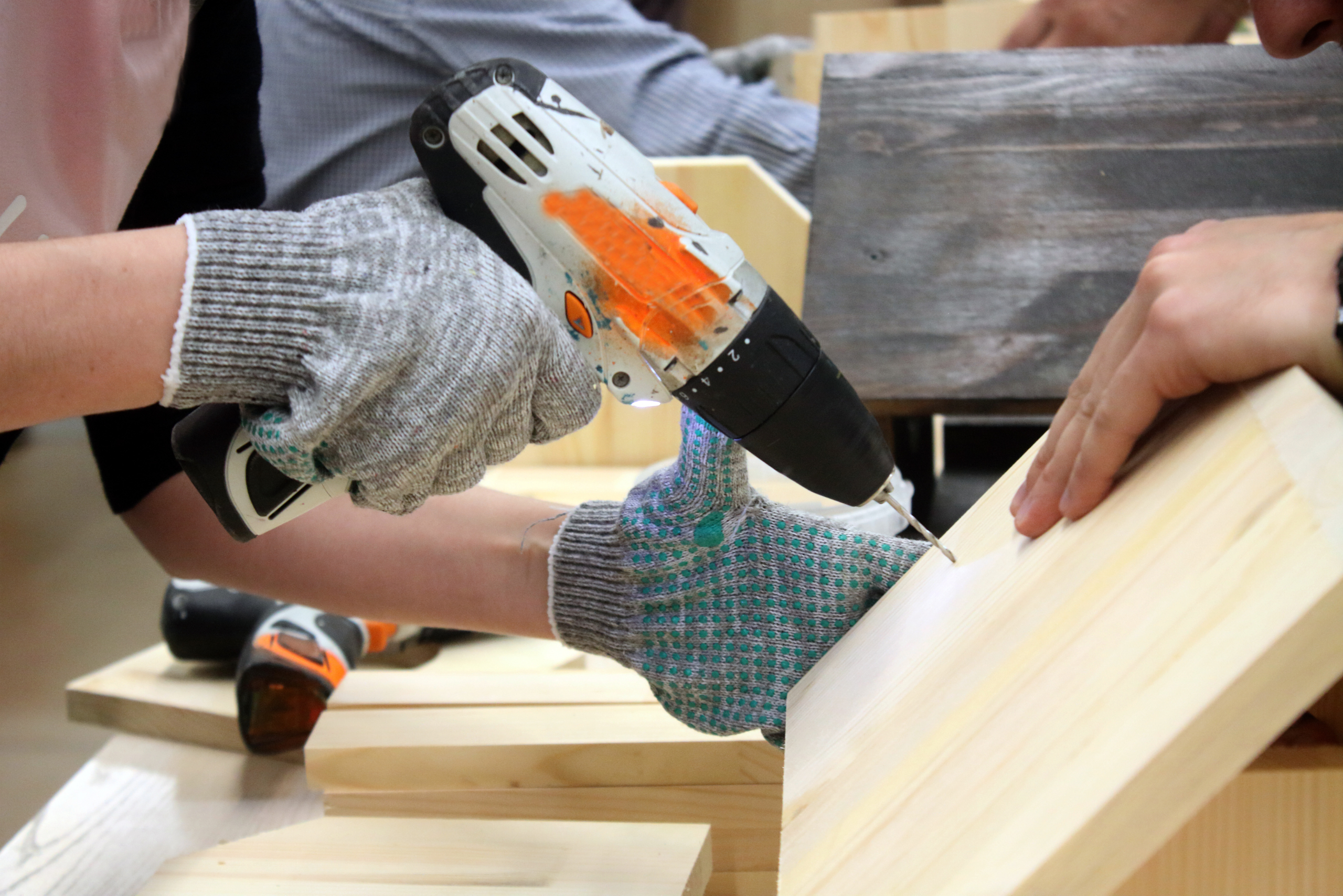 Person drilling into a piece of wood.