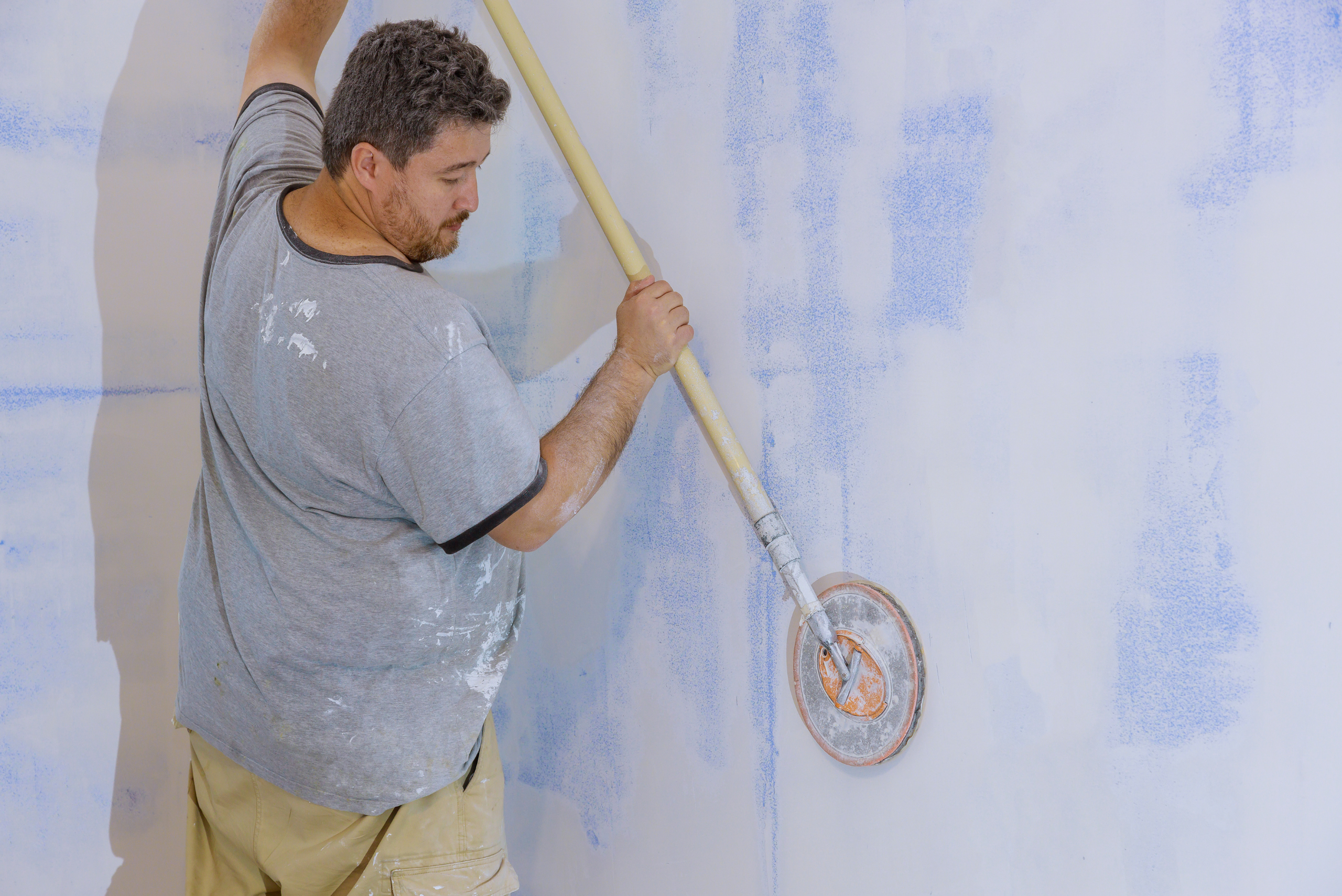 Man using sanding pole in circular motion.