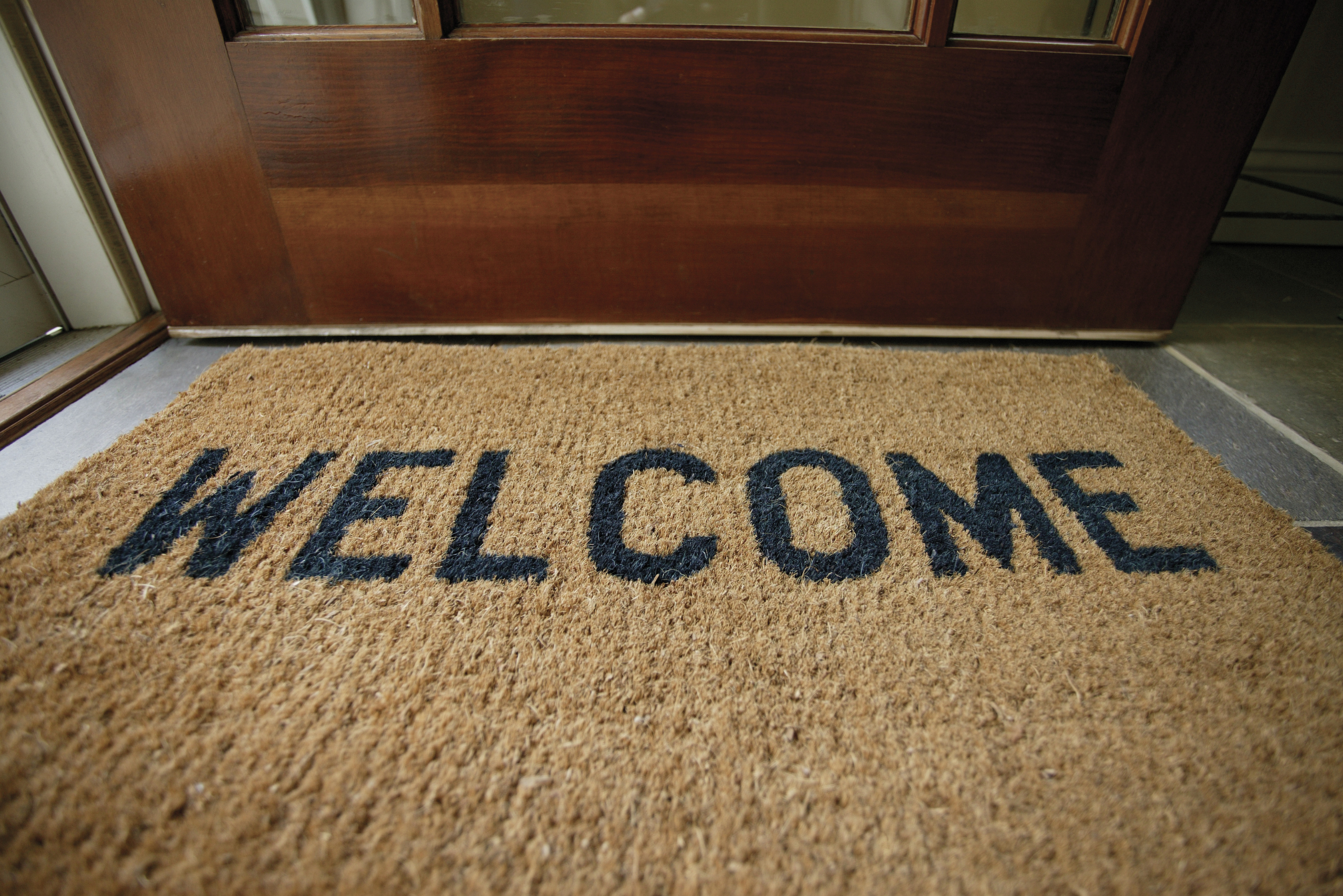 Front door mat that reads "Welcome".