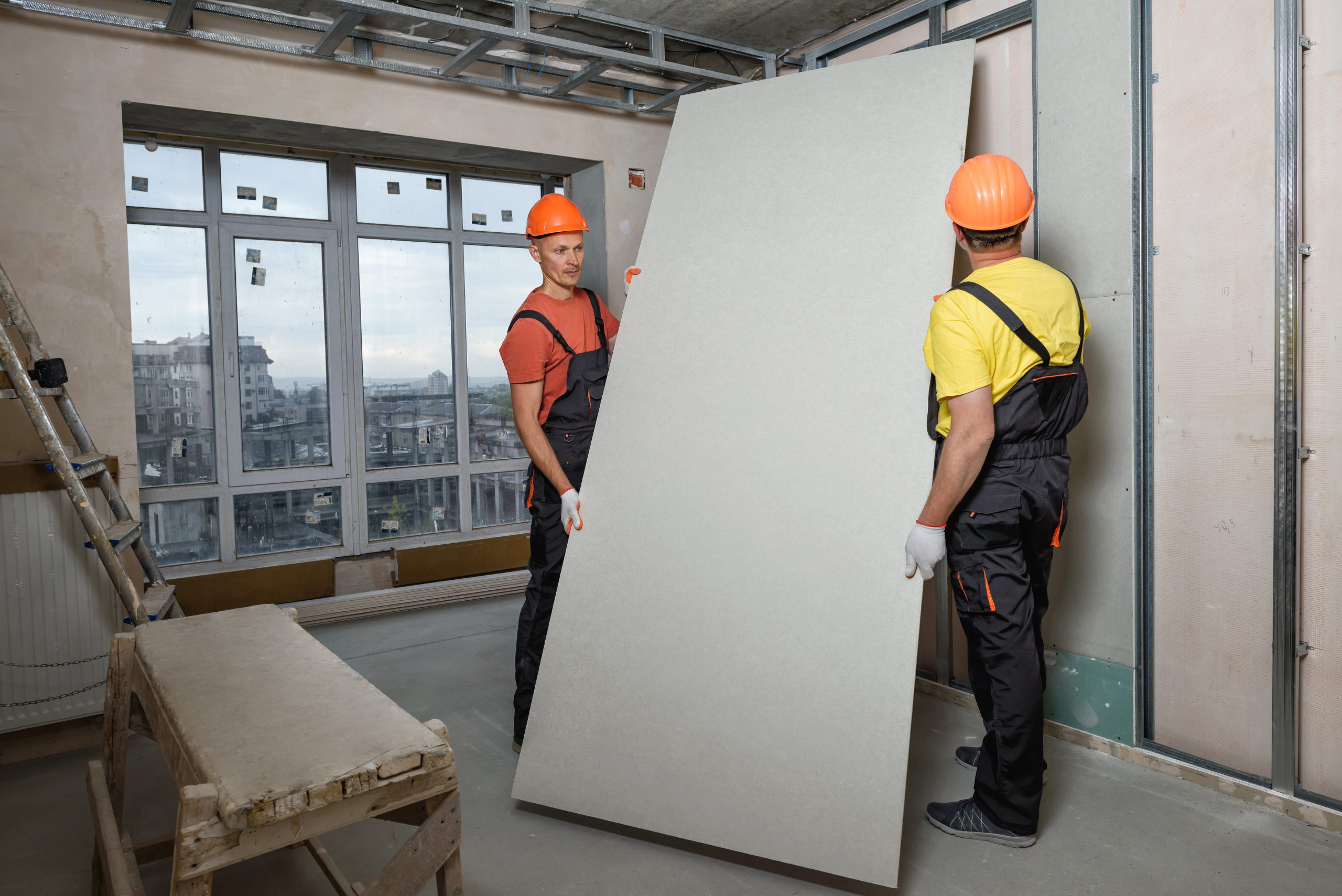 Two men installing drywall.